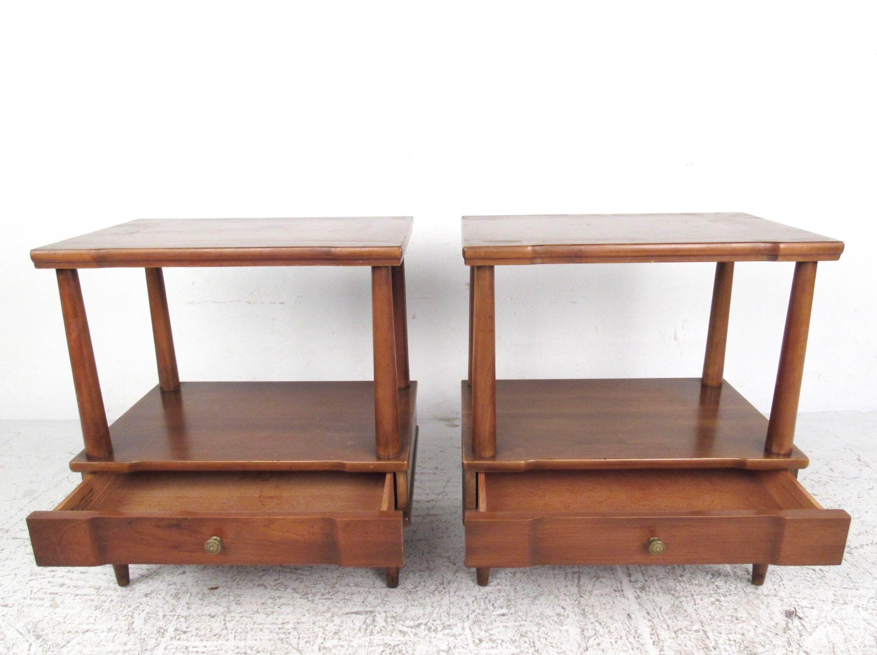 Pair of stunning vintage walnut end tables features tapered spindle frames with lower level drawer. Spacious two tier design makes these an excellent choice for bedside tables, lamp tables, or sofa end tables. Original John Widdicomb stamp in