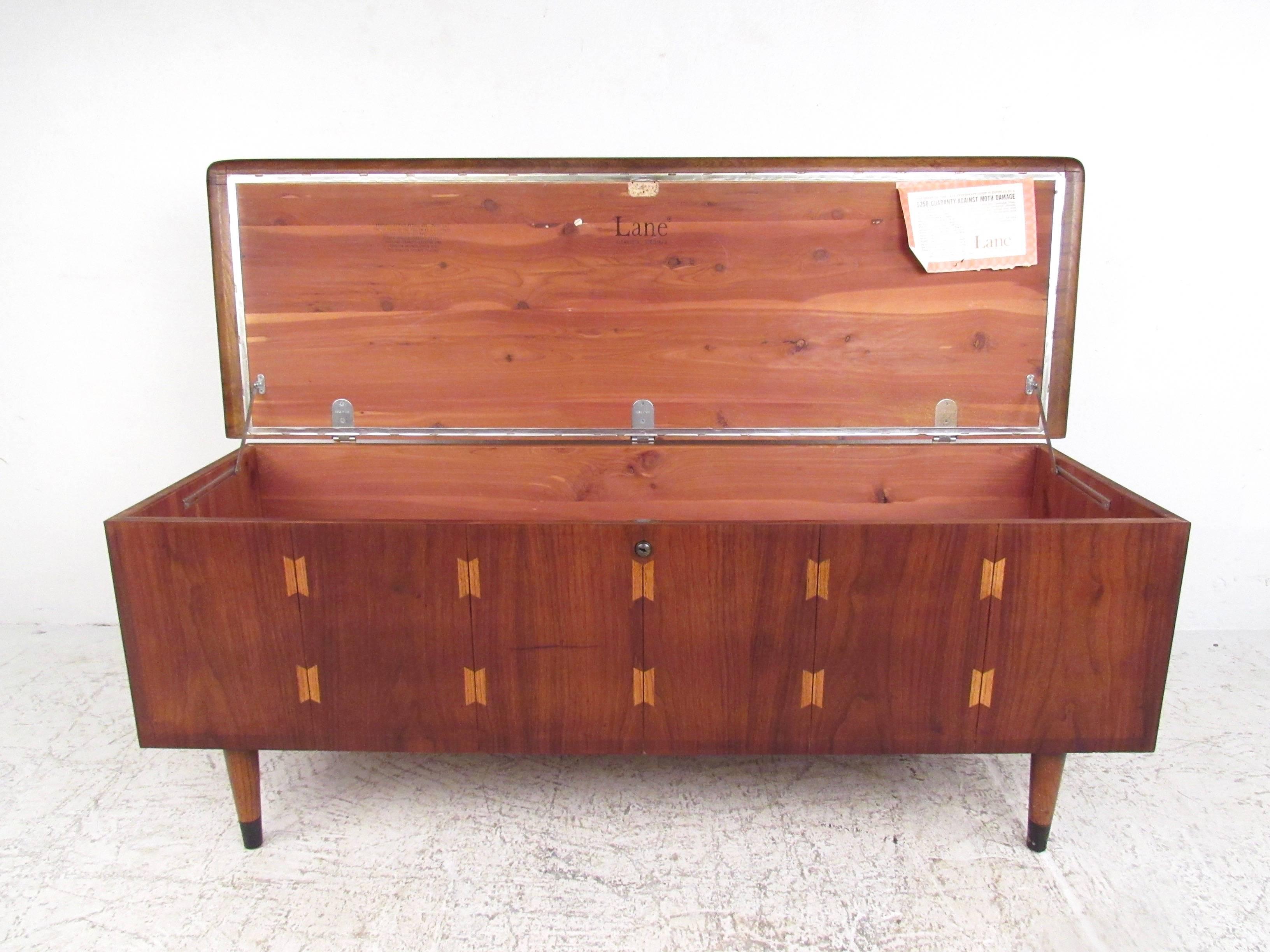This striking vintage walnut blanket chest offers cedar lined storage and features tapered legs, oak inlays, and easily doubles as an occasional bench. Manufactured by Mid-Century Furniture maker Lane, this vintage piece still has some of it's