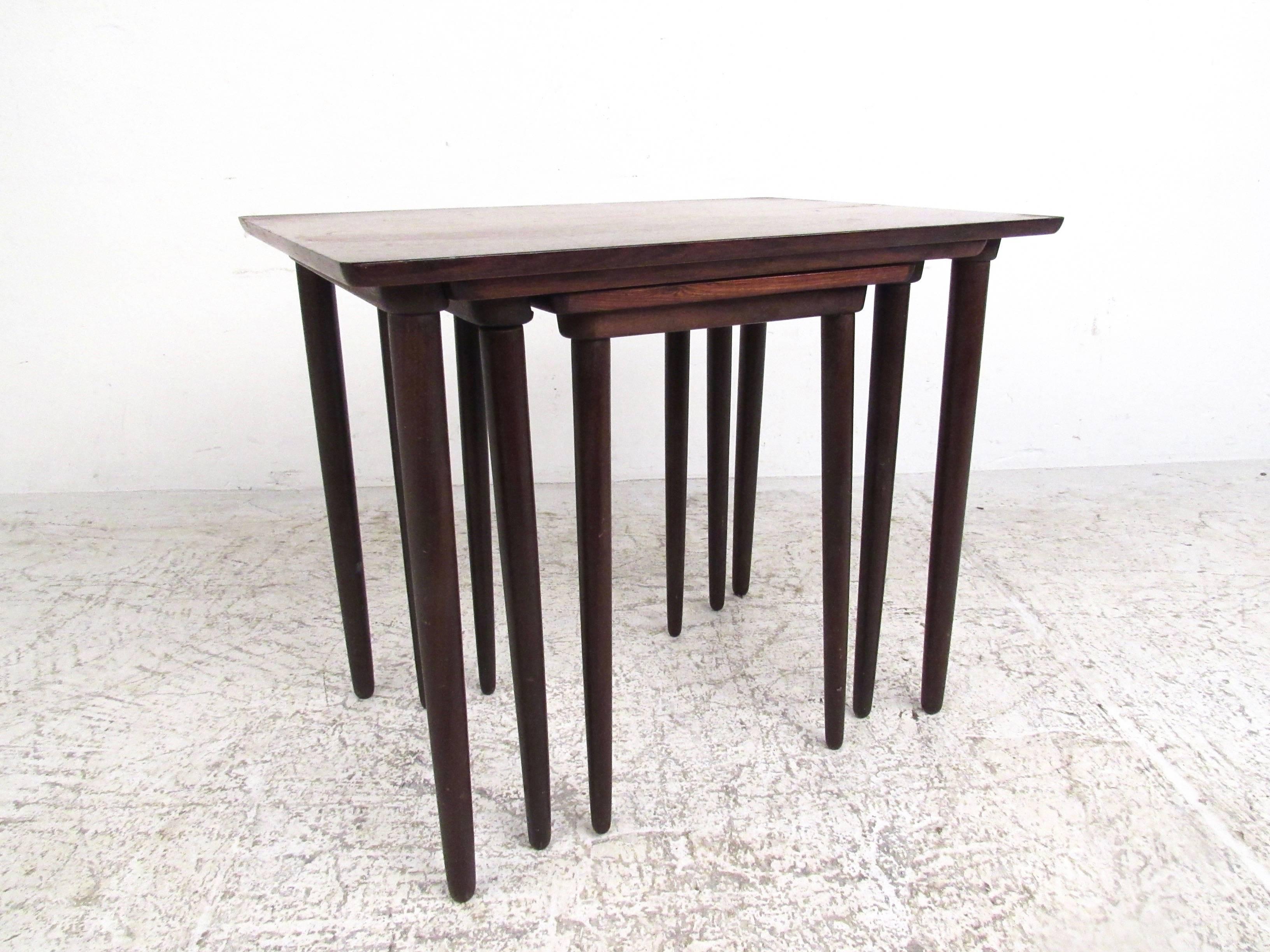 This set of three elegant vintage nesting tables features rich Mid-Century rosewood finish, tall tapered legs, and stylish lines. Manufactured by Bramin in Denmark, circa 1960s, this beautiful set makes a versatile addition to home or office. Please