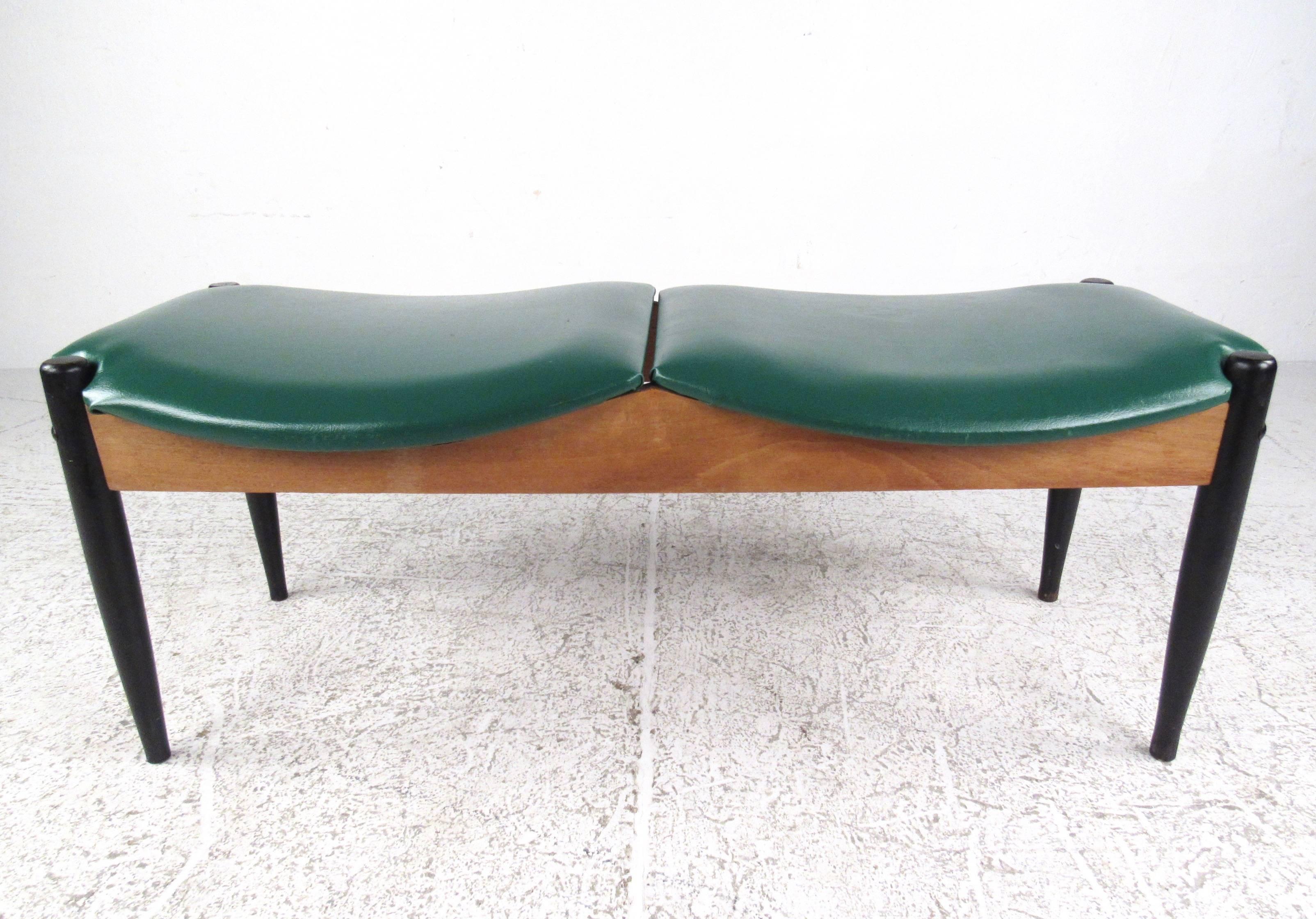 This Mid-Century two-seat window bench by John Stuart features sturdy vintage construction, comfortable padded vinyl seats, and tapered black lacquer legs. This stylish John Stuart design makes a beautiful addition to any home or office. Please