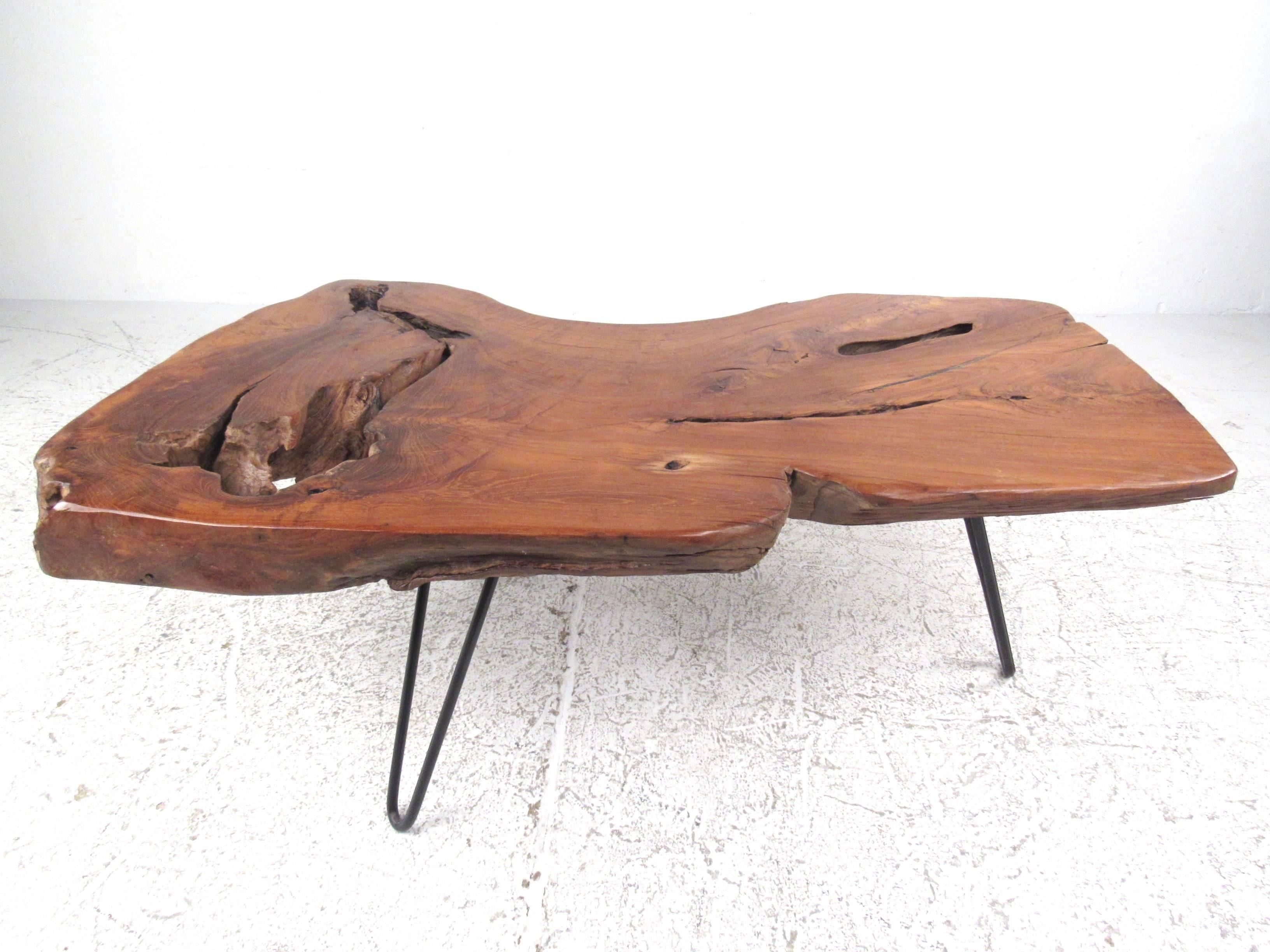 This vintage rustic coffee table features a hefty three inch slab cut of hardwood mounted on hairpin legs. Unique amorphous shape and natural imperfections add to the charm of this Mid-Century coffee table. Please confirm item location (NY or NJ).