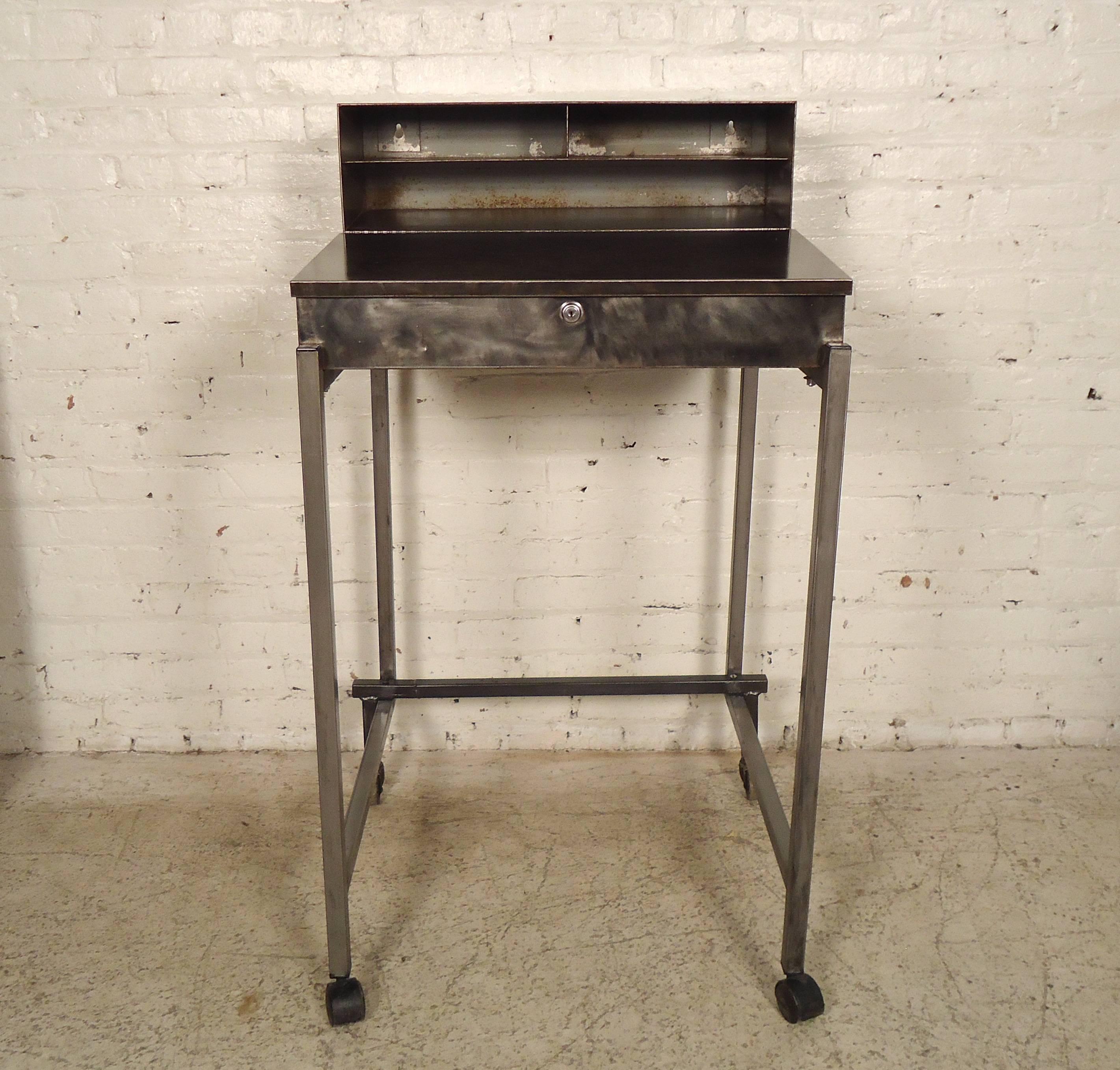 Vintage Industrial mobile factory shop desk or podium with top drawer and paper holder shelf, drawer contains a locking mechanism.
Measures: 33