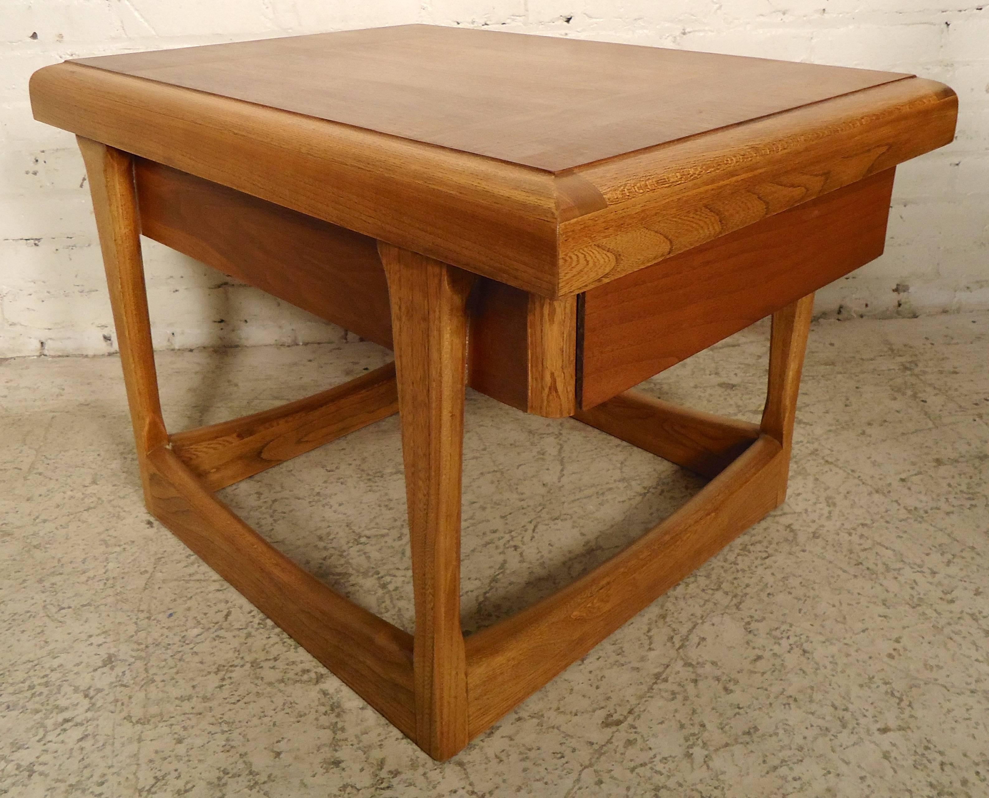 Vintage Mid-Century table with walnut grain and oak accent trim. Sculpted open frame and single drawer. Table also has a finished back.

(Please confirm item location NY or NJ with dealer).
 