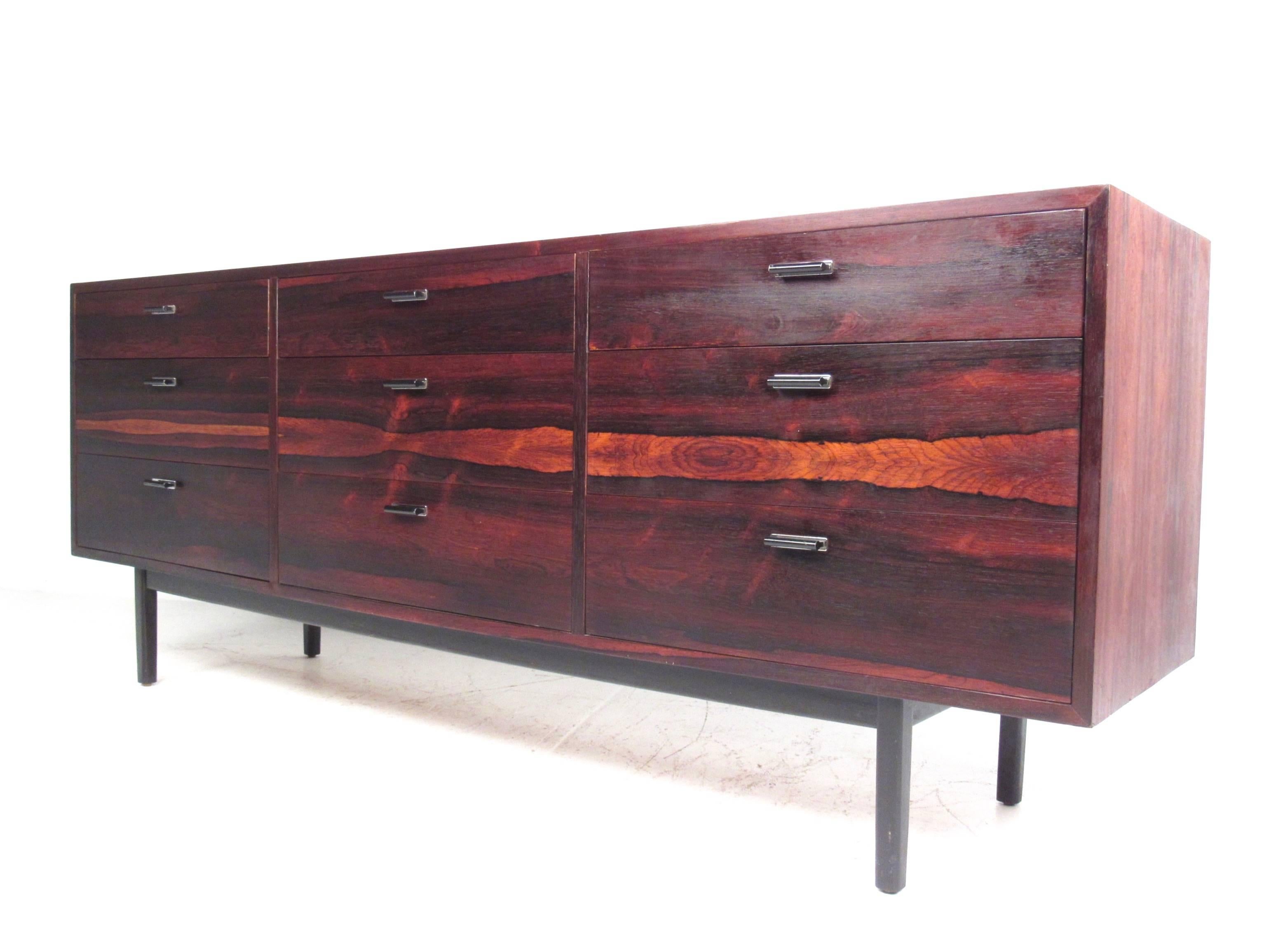 This stunning Mid-Century Modern dresser features nine spacious drawers for storage, unique Florence Knoll style design, and a beautiful vintage Rosewood finish. Stylish metal pulls and the vibrant wood finish make this an impressive addition to