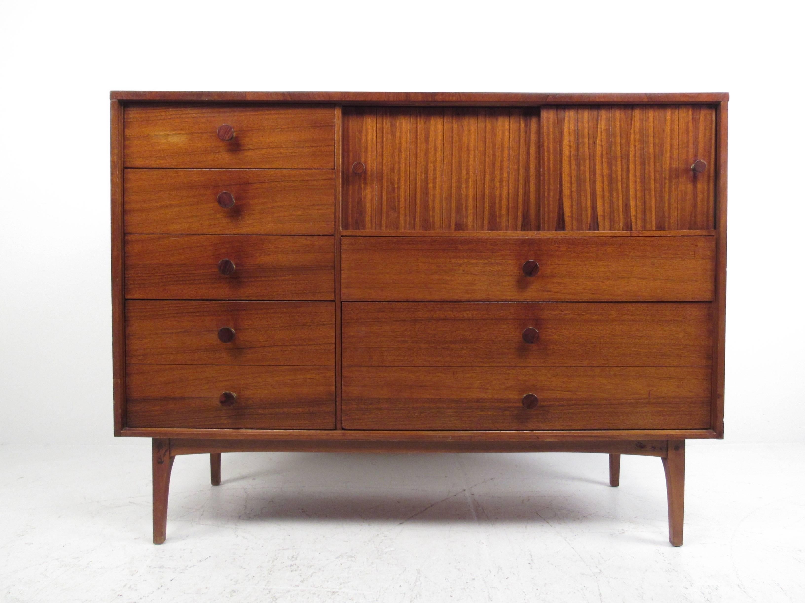 This unique vintage dresser features beautiful wood finish, with rarely seen circular brass and rosewood drawer pulls. The unique size of this Mid-Century Modern lane furniture dresser makes it a stylish and impressive storage piece or television