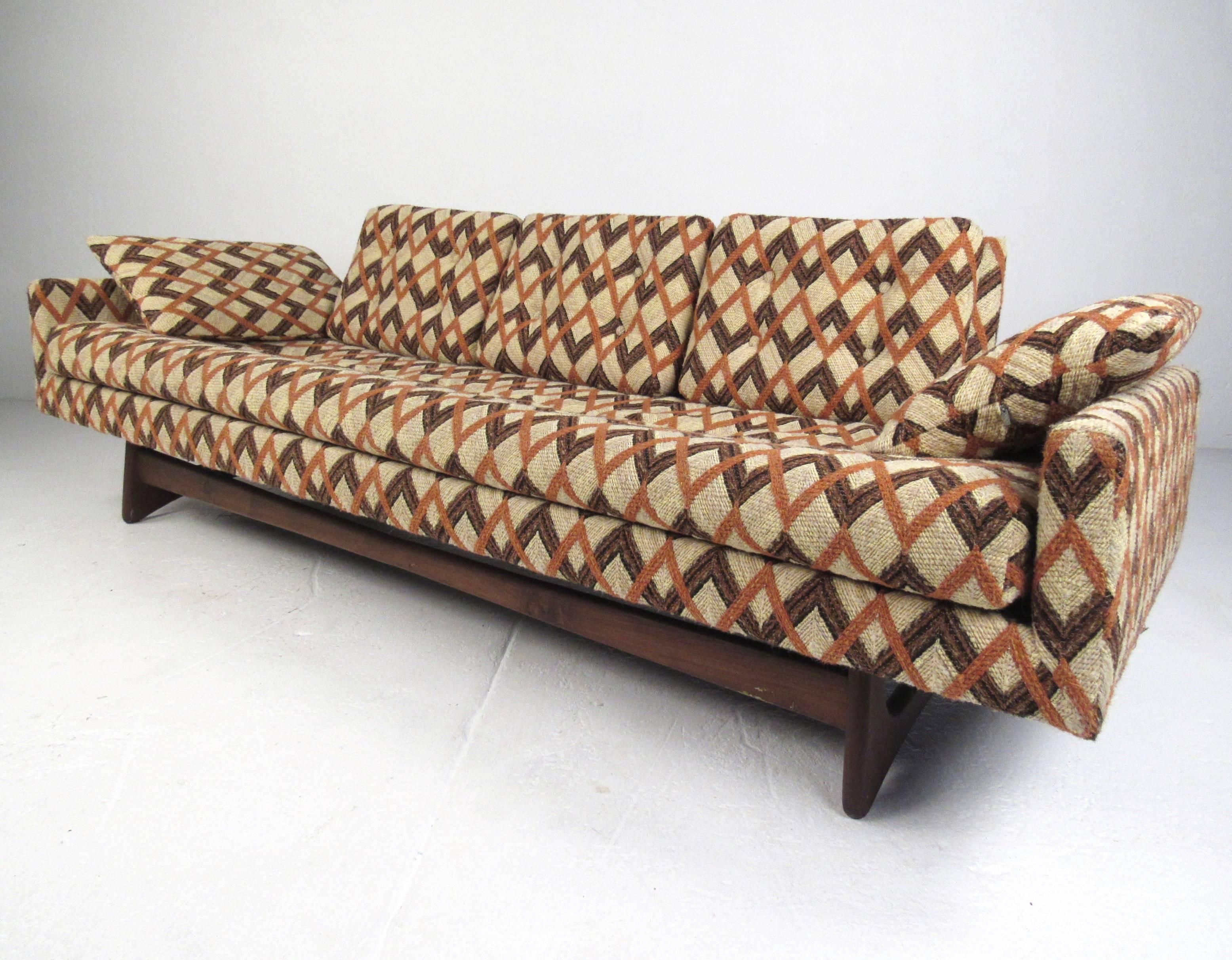 This large Adrian Pearsall sofa features unique sculpted walnut legs and a unique and stylish design. Tufted vintage upholstery further accentuates the Mid-Century Modern appeal of this Craft Associates four seat sofa. Please confirm item location