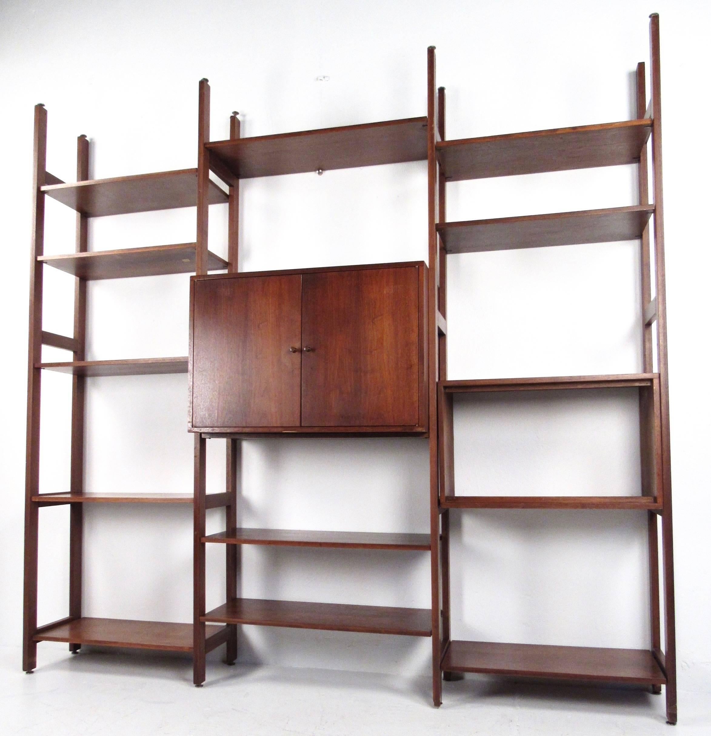This impressive vintage walnut entertainment unit offers a wide variety of shelf space for display and storage, as well as a center cabinet for concealed organization. Adjustable shelf and cabinet placement allows you to modify the unit to your