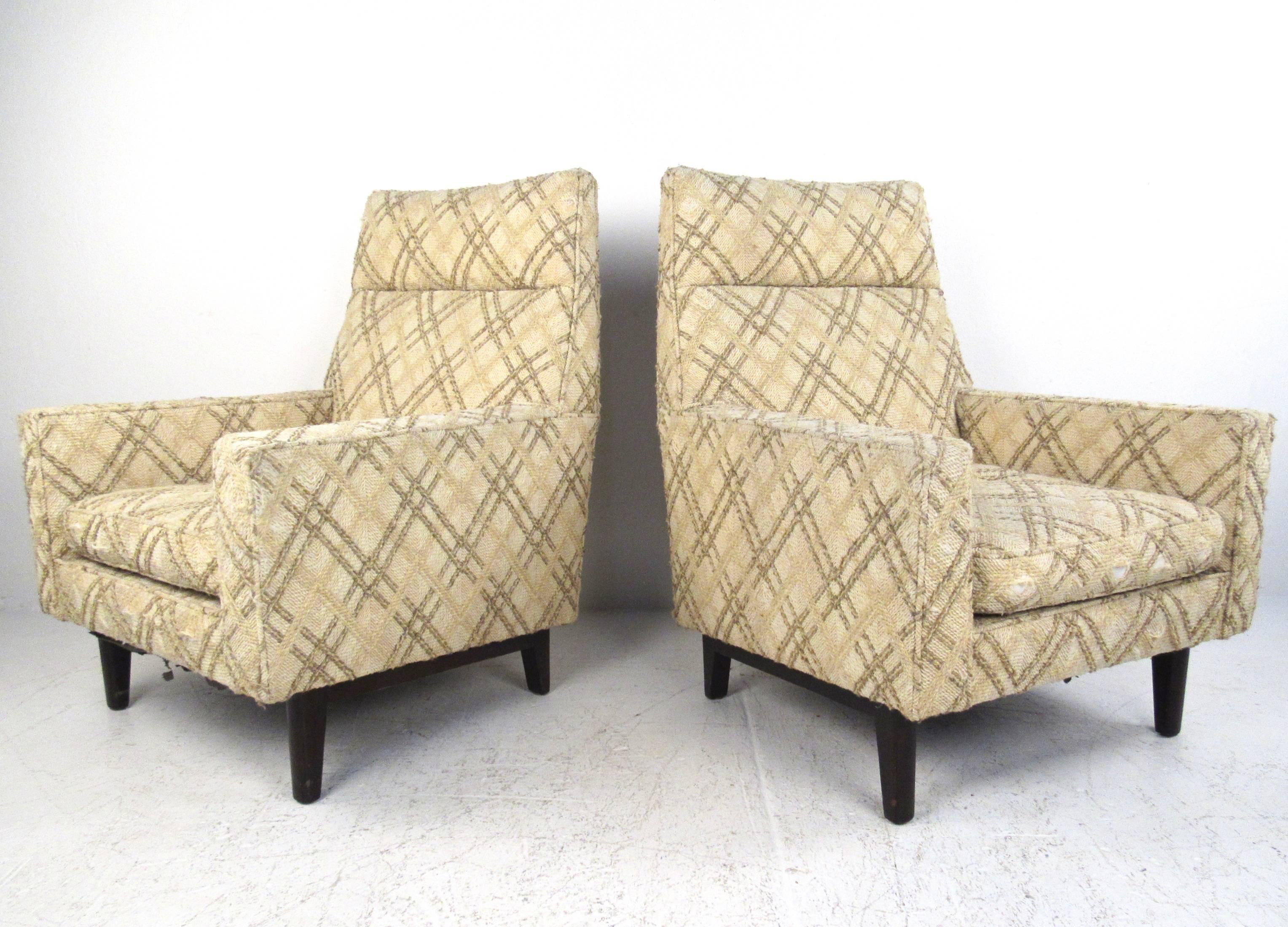This pair of 1950s high back lounge chairs by Edward Wormley for Dunbar features iconic Mid-Century design and comfortably sculpted seat backs. Spacious seats with plush vintage fabric make these an ideal pair of modern chairs for any setting.
