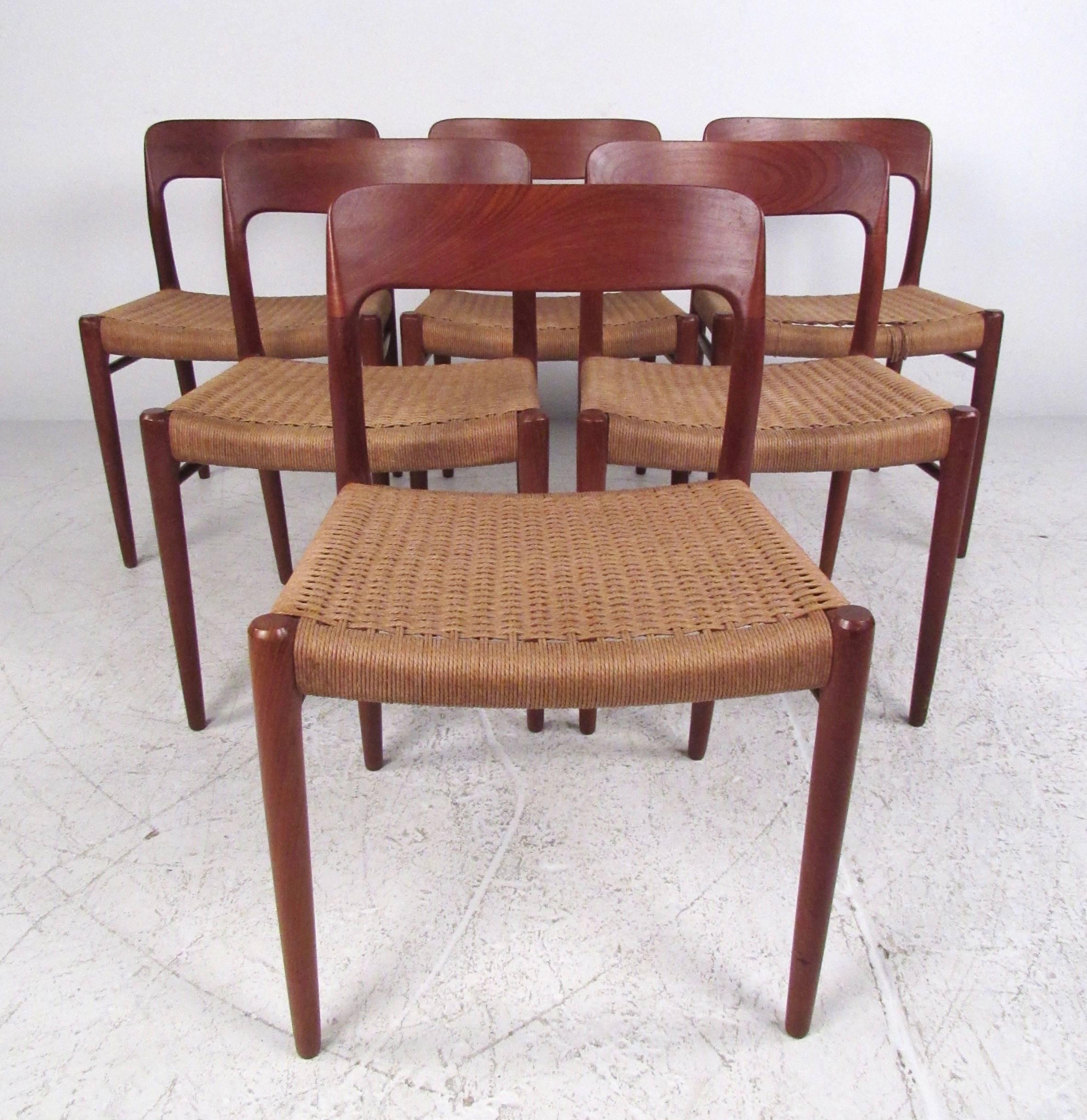 This Mid-Century teak dining set features six stylish Niels Otto Møller dining chairs paired with an unmarked circular dining table.  The comfortable sculpted teak chairs feature woven papercord seats with side stretchers for added stability. Please