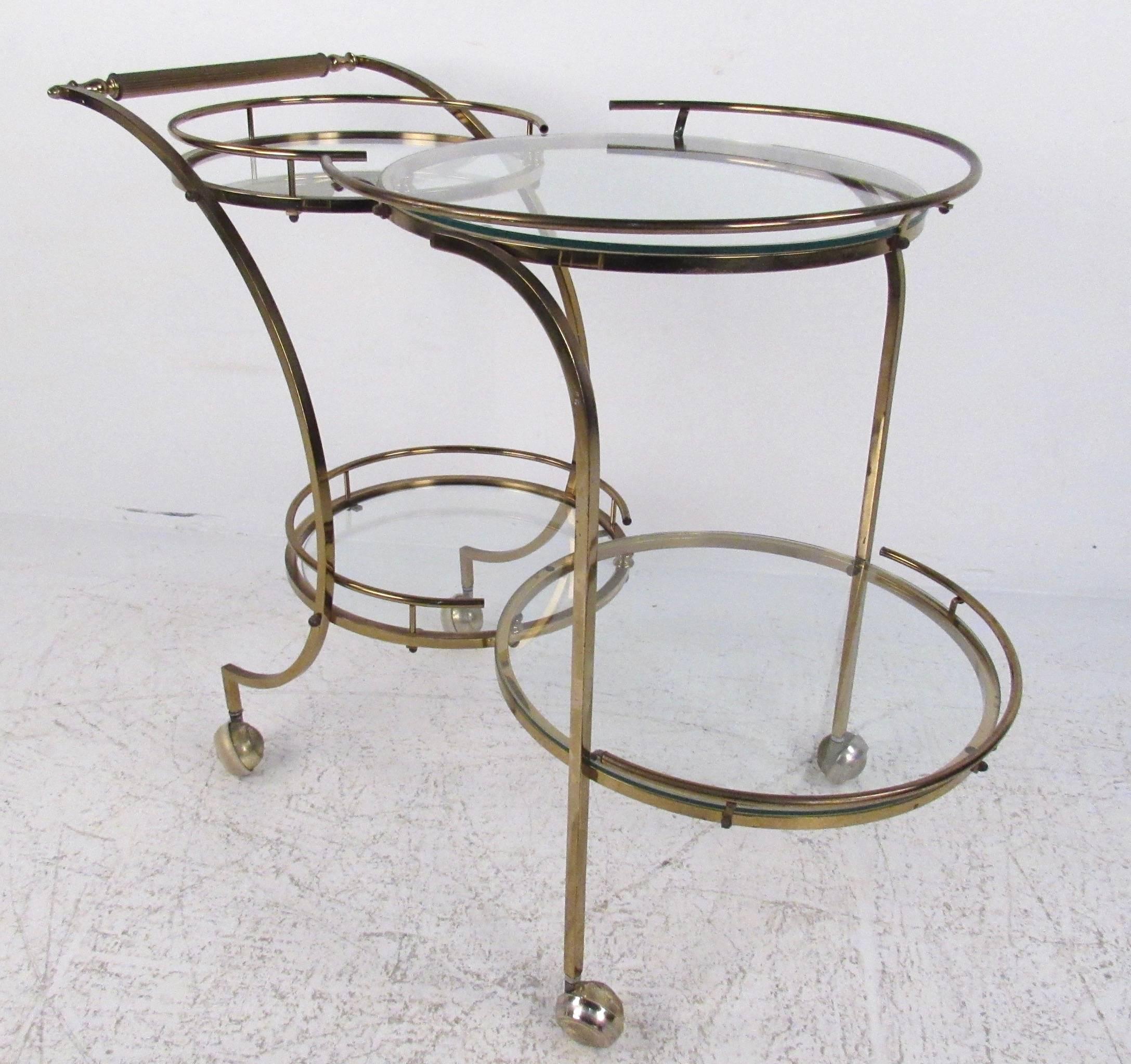 This vintage Italian brass bar cart features elegant lines and four tier circular shelves for storage and service. Stylish Mid-Century serving cart boasts slender elegant frame and hardwood handle, making a versatile and beautiful addition to any