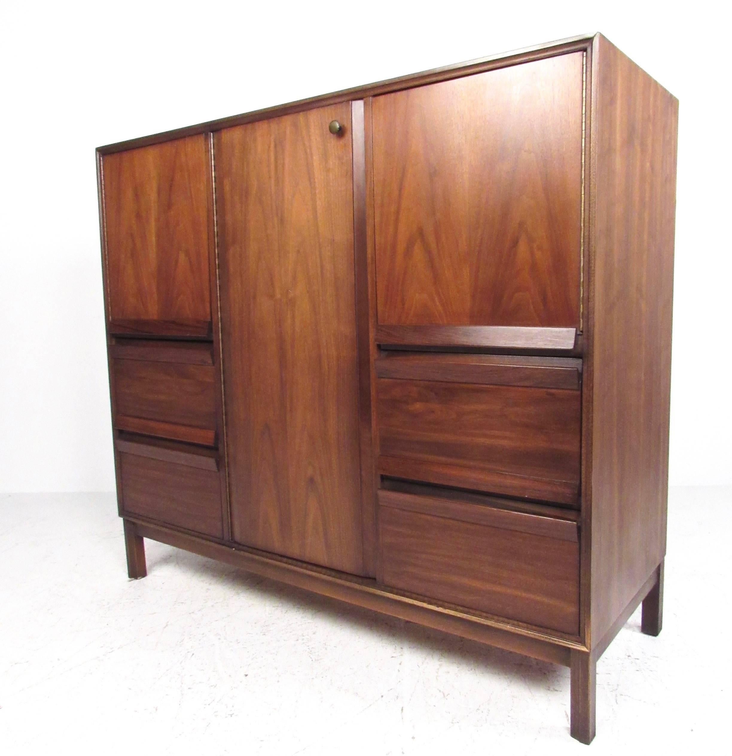 This vintage dresser features beautiful walnut finish with plenty of storage for any setting. Spacious bottom drawers are balanced by shelved storage cabinets, all with unique pulls. This large armoire is perfect for bedroom storage; please confirm