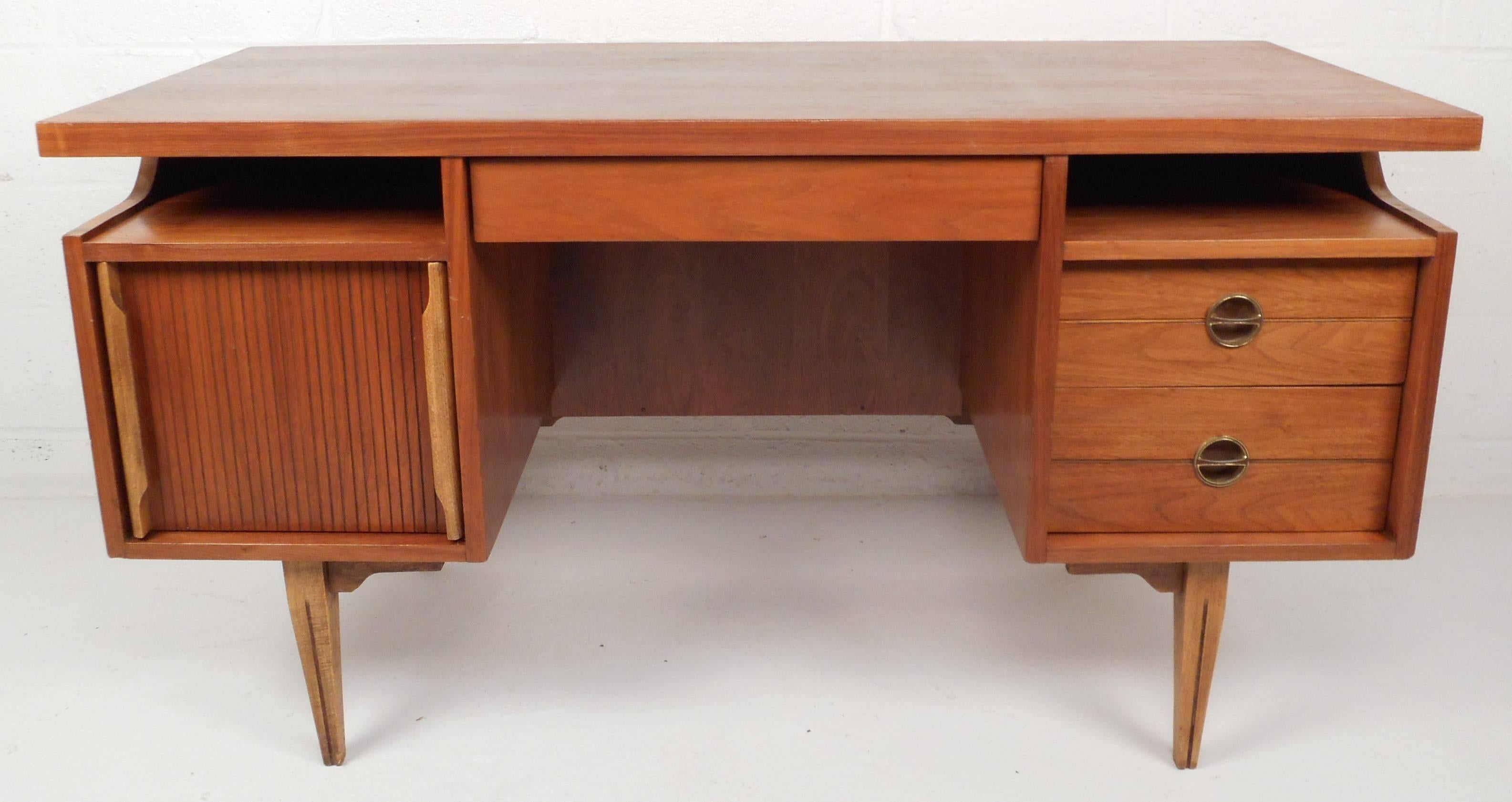 Stunning vintage modern walnut desk features the iconic floating top that Hooker Furniture is known for. Unique design offers plenty of room for storage with three dovetail drawers and one large file drawer. Beautiful sculpted brass pulls and