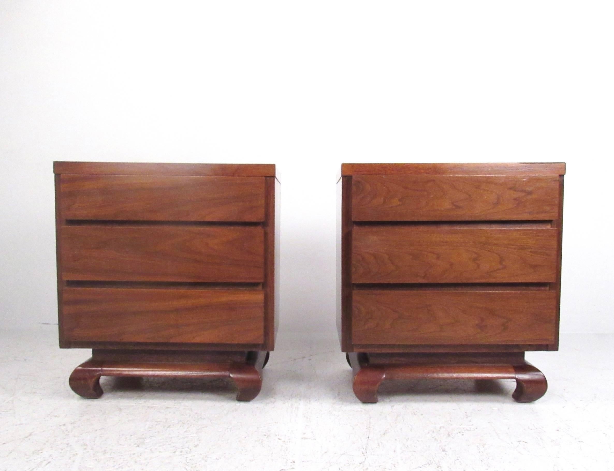 This pair of vintage walnut nightstands by American of Martinsville feature beautiful sculpted feet and three spacious drawers for bedside storage. Please confirm item location (NY or NJ).