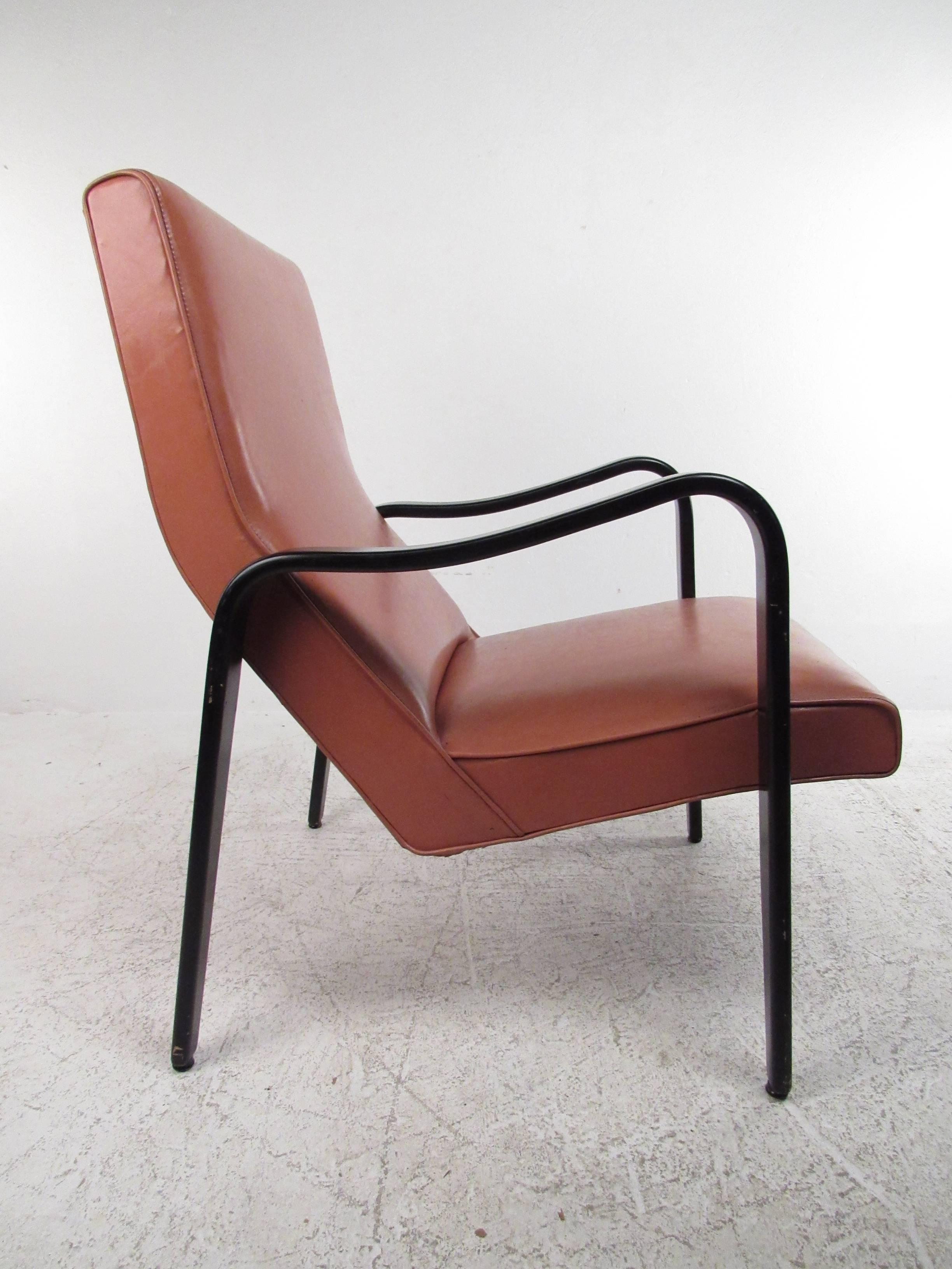 This vintage modern lounge chair features slender black lacquered frame with durable vinyl upholstery. The uniquely sloped high back armchair makes this comfortable chair the perfect addition to any Mid-Century interior. Please confirm item location