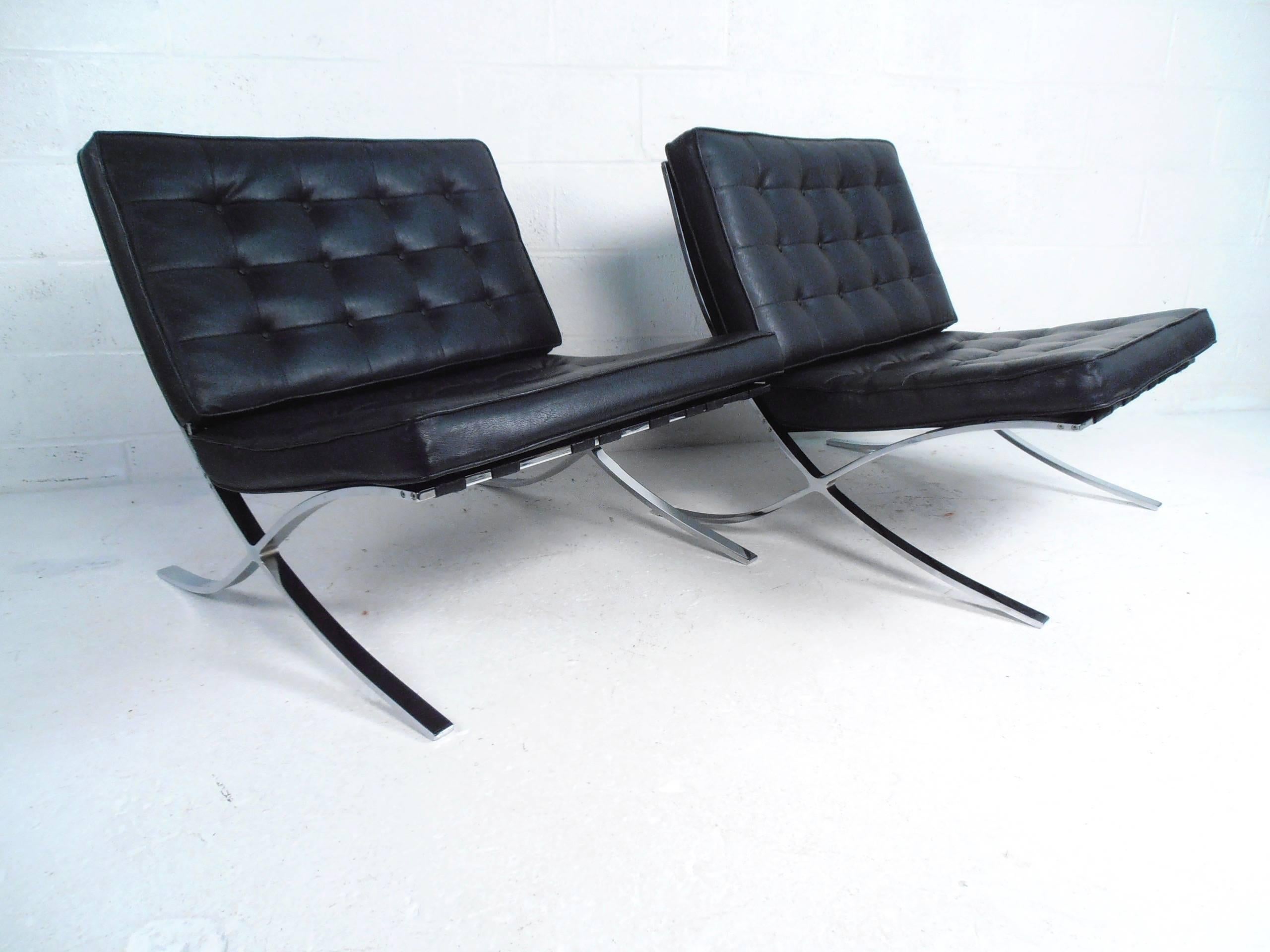 This pair of vintage modern lounge chairs feature stylish chrome frames and tufted vinyl upholstery. The stylish Mid-Century design of the pair are in the style of Mies van der Rohe and make a lovely addition to any interior. Please confirm item