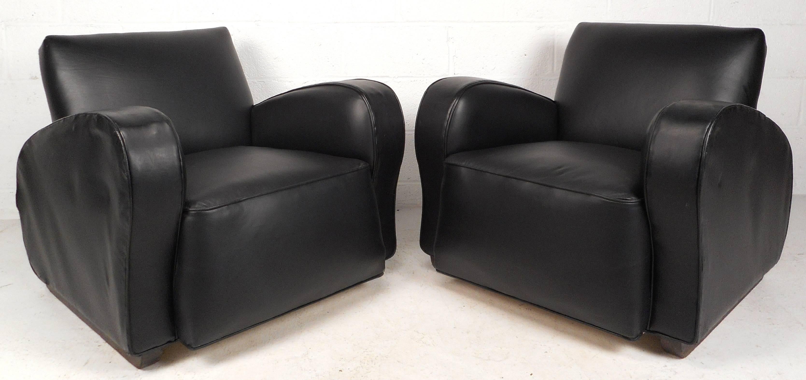 Impressive pair of contemporary modern Art Deco style lounge chairs feature black vinyl upholstery and unique sculpted arm rests. The shapely design is sure to provide the utmost comfort and style in any modern interior. Please confirm item location
