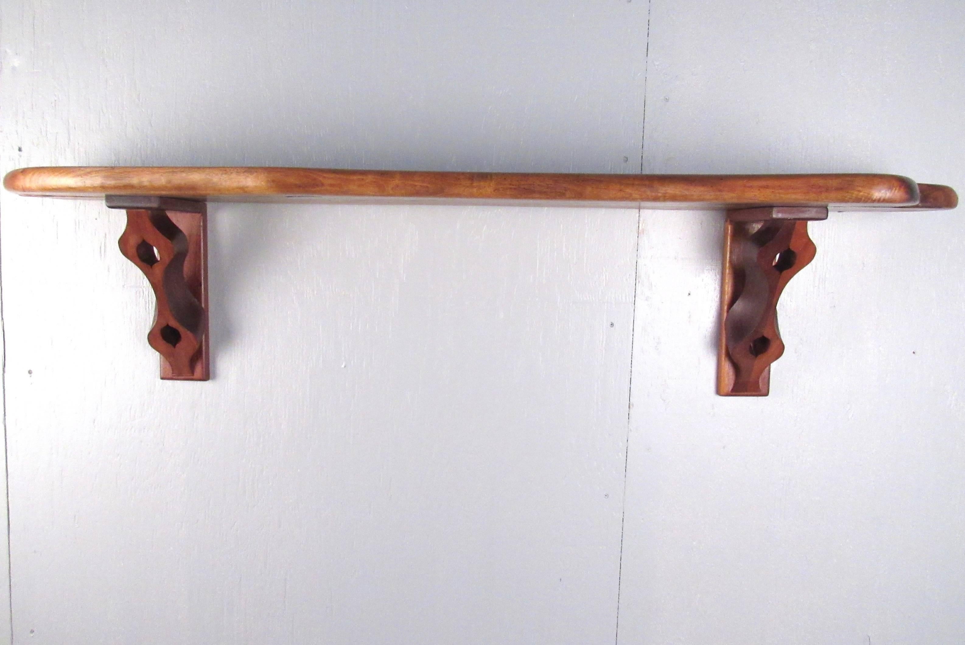 This vintage live edge wall shelf features a beautiful free-form tree slab shelf with unique sculpted hardwood brackets. This stylish wall shelf is perfect for home or office display and makes a lovely rustic addition to any setting. Please confirm