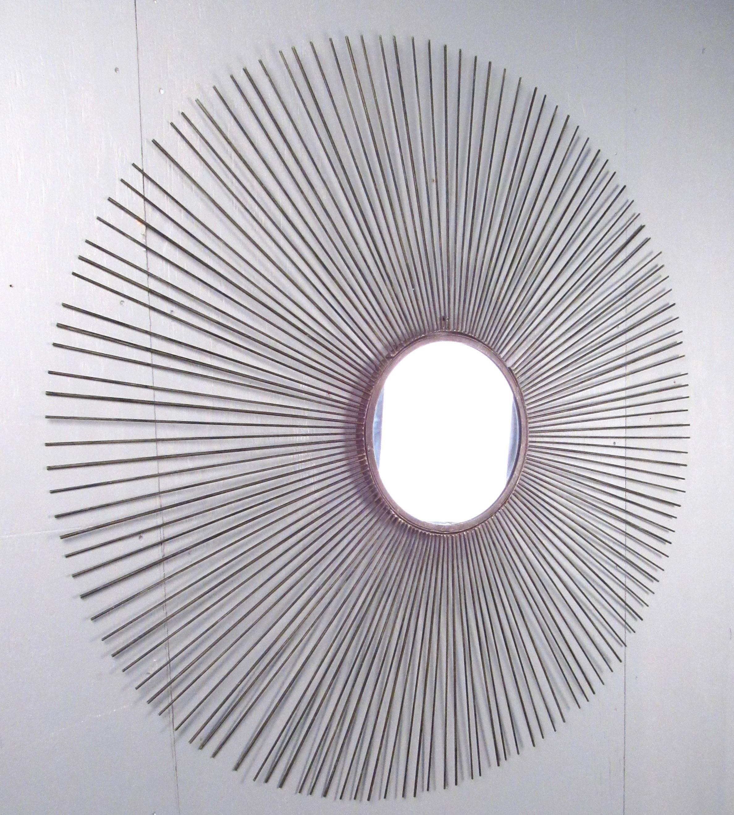 This large starburst mirror features elegant iron spokes around a small centre mirror. This impressive Mid-Century design makes this stellar sunburst design a beautiful addition to any home or office. Please confirm item location (NY or NJ).