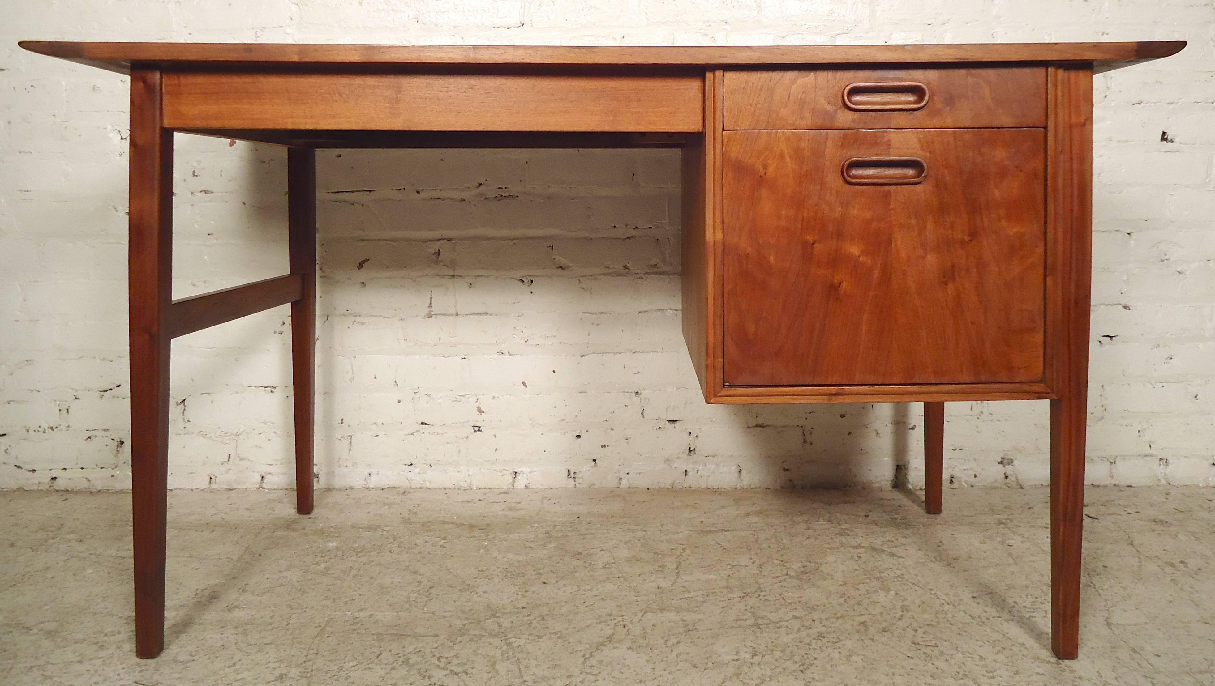 Mid-Century Modern teak desk with slate insert top. Simple modern lines, large writing surface, two drawers with sculpted pulls and fine tapered legs.
Measures: Kneehole 25" W, 23" D, 25" H.

(Please confirm item location-NY or