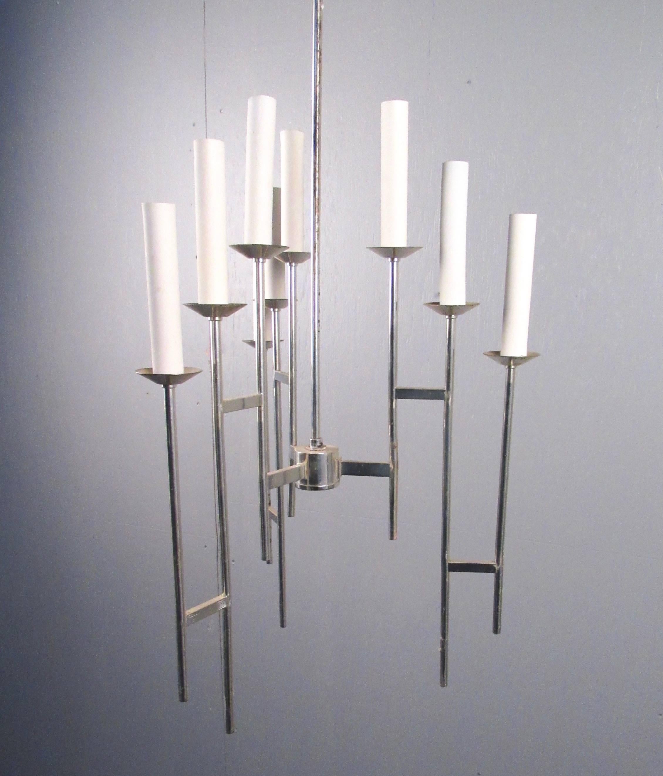 This vintage modern hanging light fixture features nine candlestick style light fixtures in a modernistic chrome finish chandelier. Slender and stylish, this vintage lighting is ready for some gentle rehab and a new home. Please confirm item