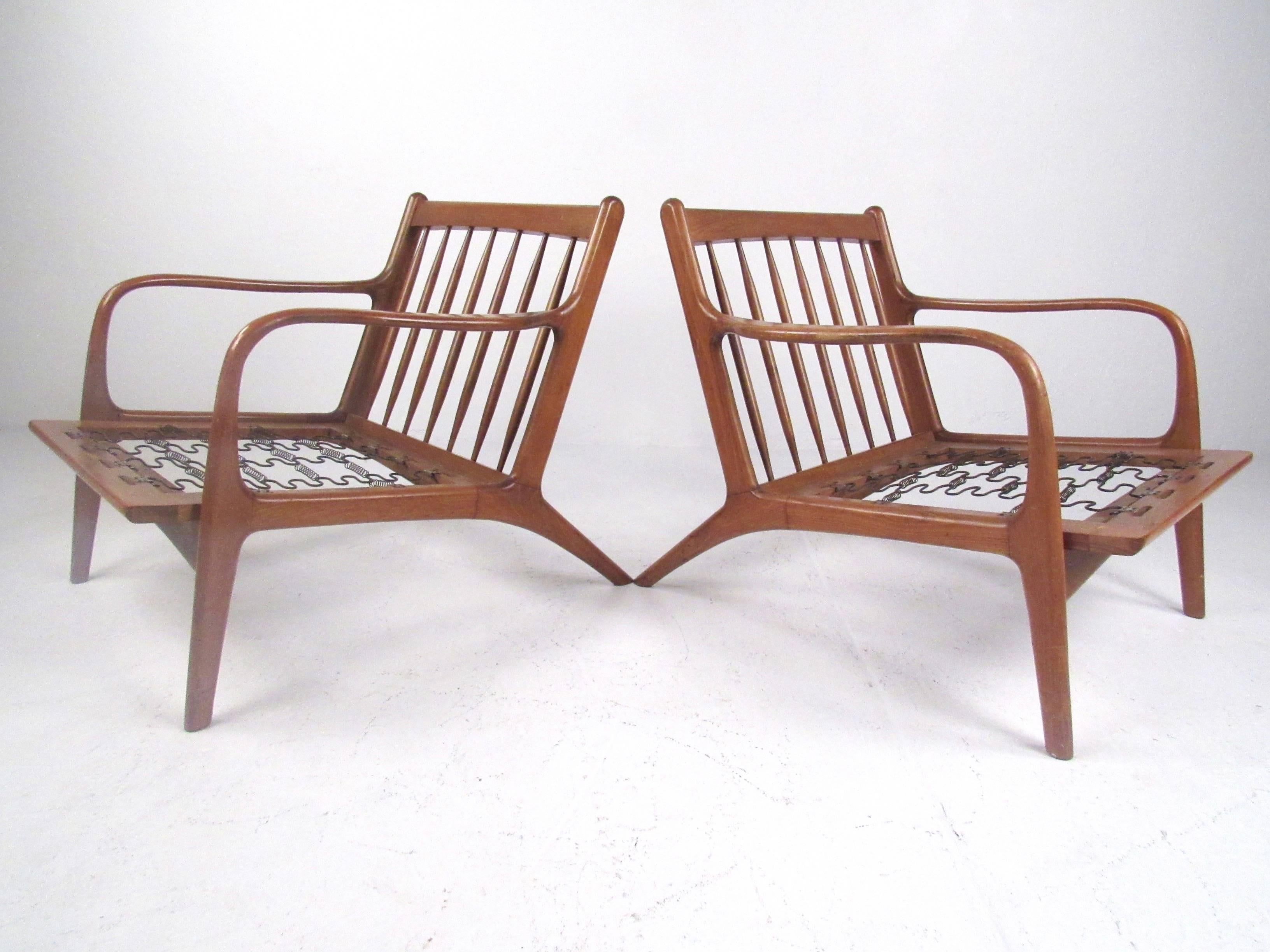 This Mid-Century pair of walnut lounge chairs features stylish Danish modern design with serpentine spring upholstery. Unique pair features the vintage style of Folke Ohlsson and makes a beautiful addition to any interior. Please confirm item