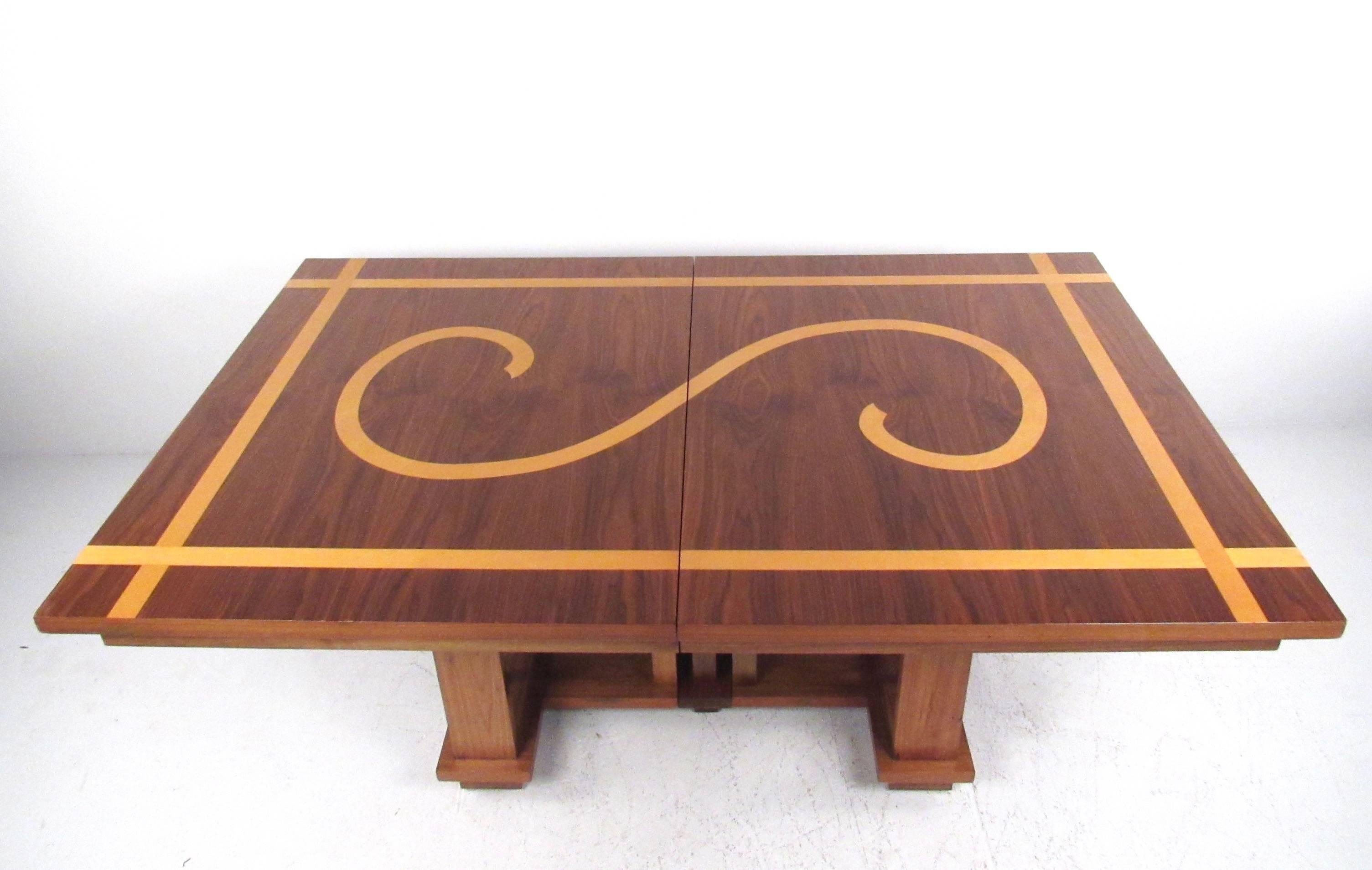 This vintage modern dining table features a rich hardwood table with decorative oak inlay. The table opens from 70.25w to include an additional four leaves, opening up to twice its original size. The sculpted style of the base is reminiscent of