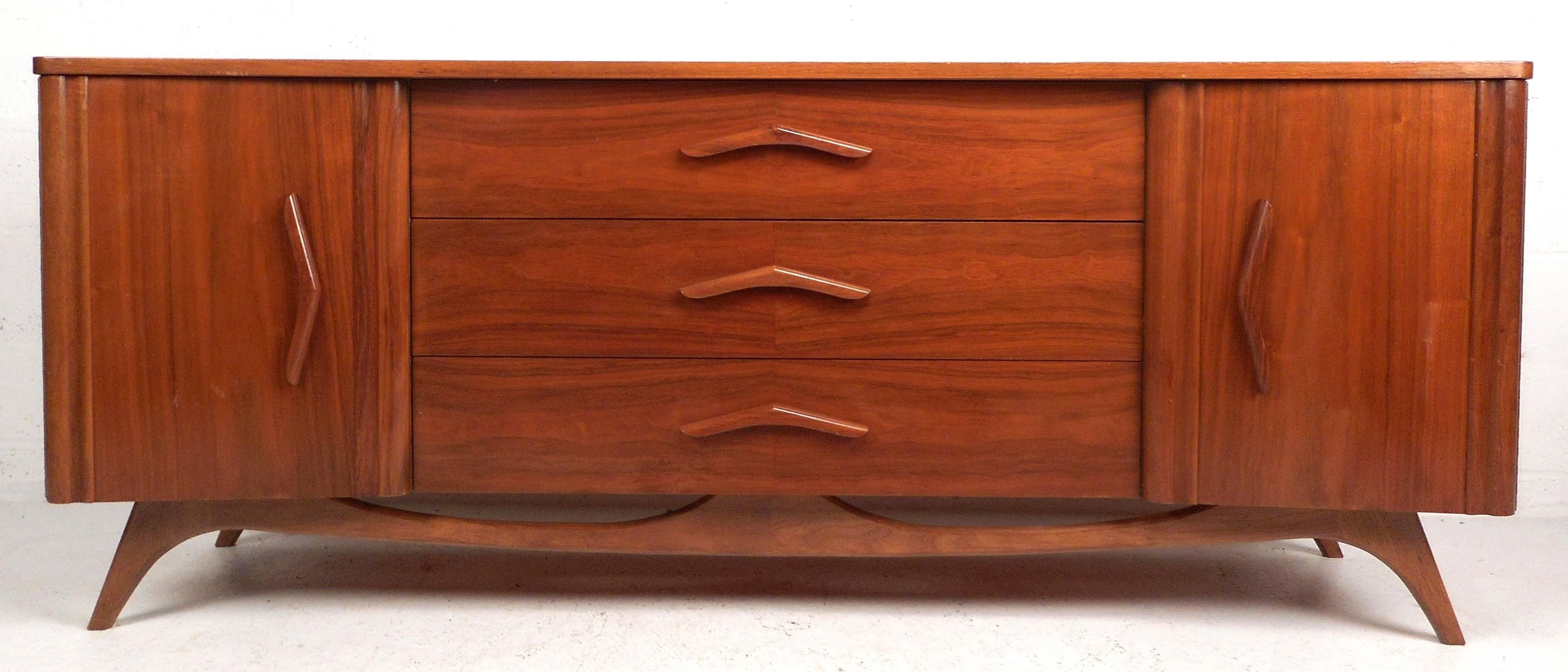 Impressive vintage modern curved front dresser features nine hefty drawers providing plenty of room for storage. Sleek design with carved pulls and a unique sculpted base. Sturdy construction and beautiful walnut wood grain make this bedroom dresser