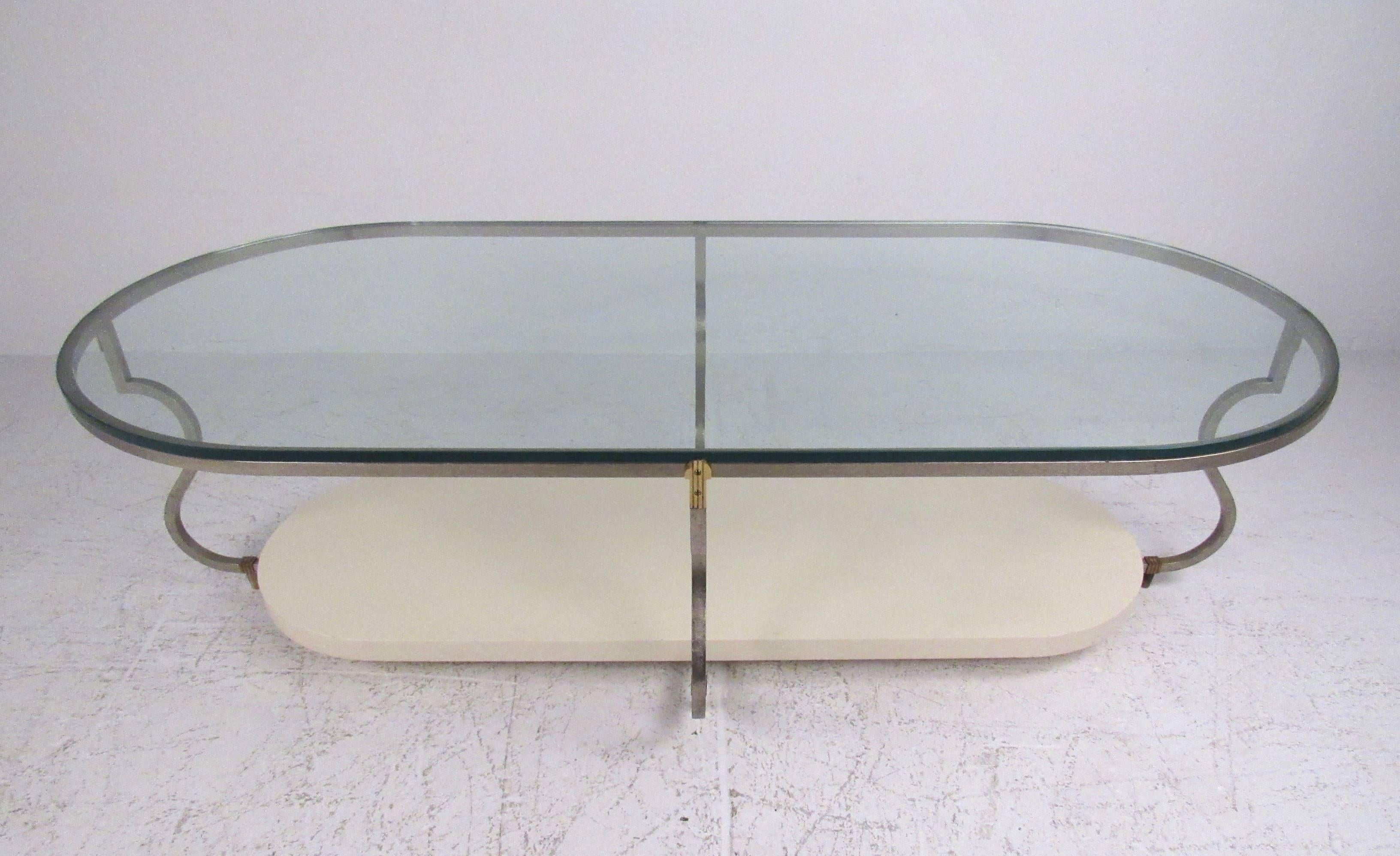 This stylish vintage coffee table features elegant sculpted metal frame with two-tier construction. The beautiful Mid-Century design of Tommi Parzinger is evident in this obround coffee table and bears the original 