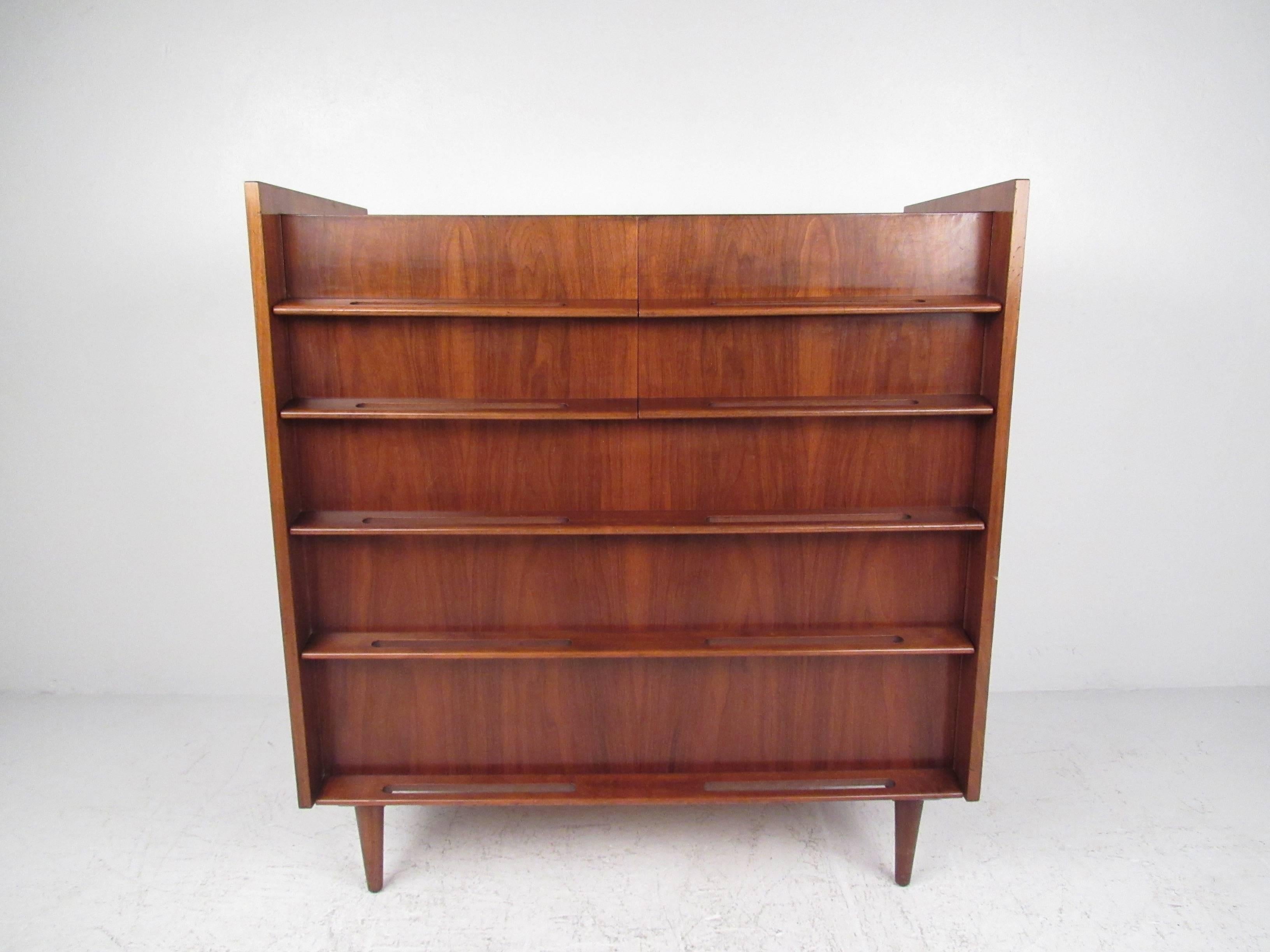 This Mid-Century bedroom set by Edmond Spence features beautiful vintage teak construction and includes a long low dresser, matching highboy, pair of nightstands, and king-size headboard. The stylish carved handles and raised edges make this iconic