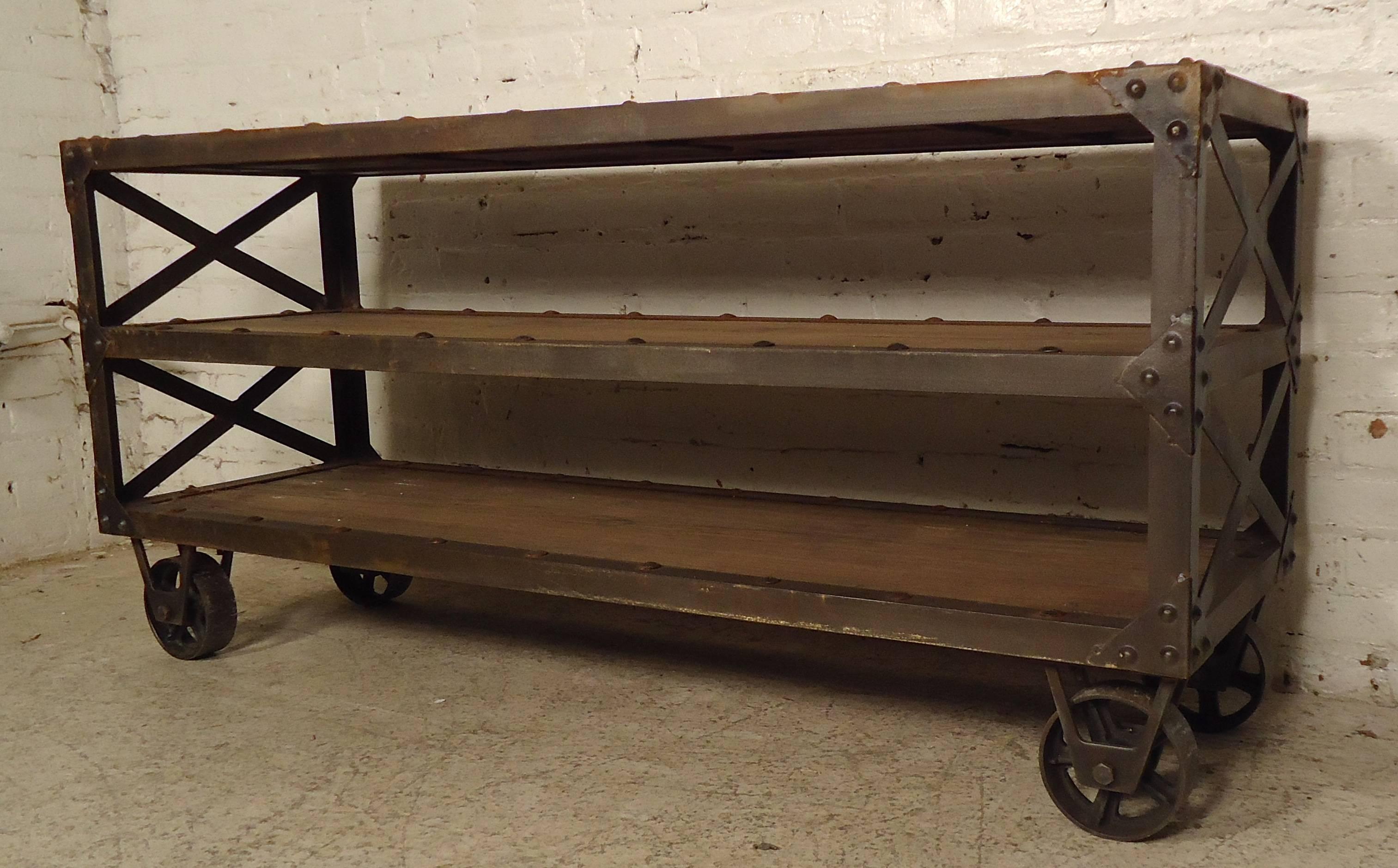 This vintage-modern rolling cart features thick wood slabs providing shelving for each tier on a set of four large caster wheels.

 Please confirm item location (NY or NJ) with dealer.