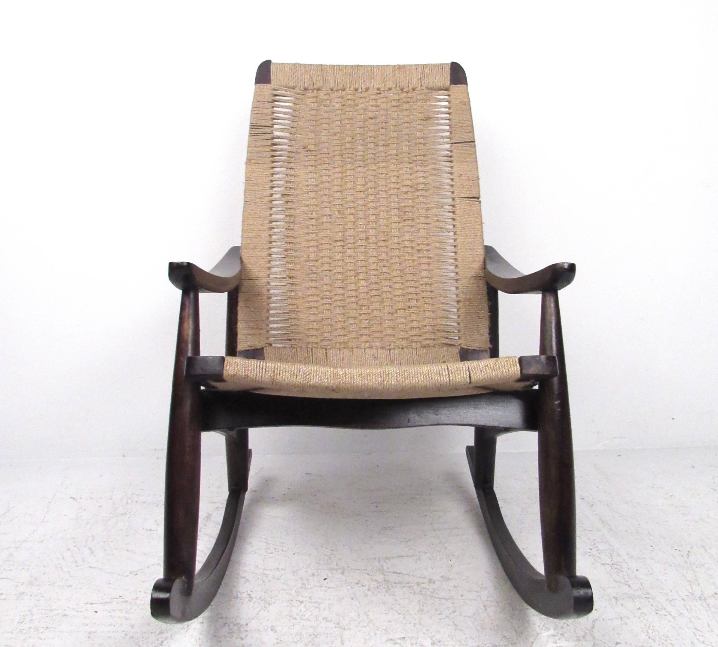 This vintage modern rocking chairs features woven seat on a hardwood frames. Angled armrests and comfortable proportions add to the Mid-Century charm of this Hans Wegner style rocking chair. Please confirm item location (NY or NJ).