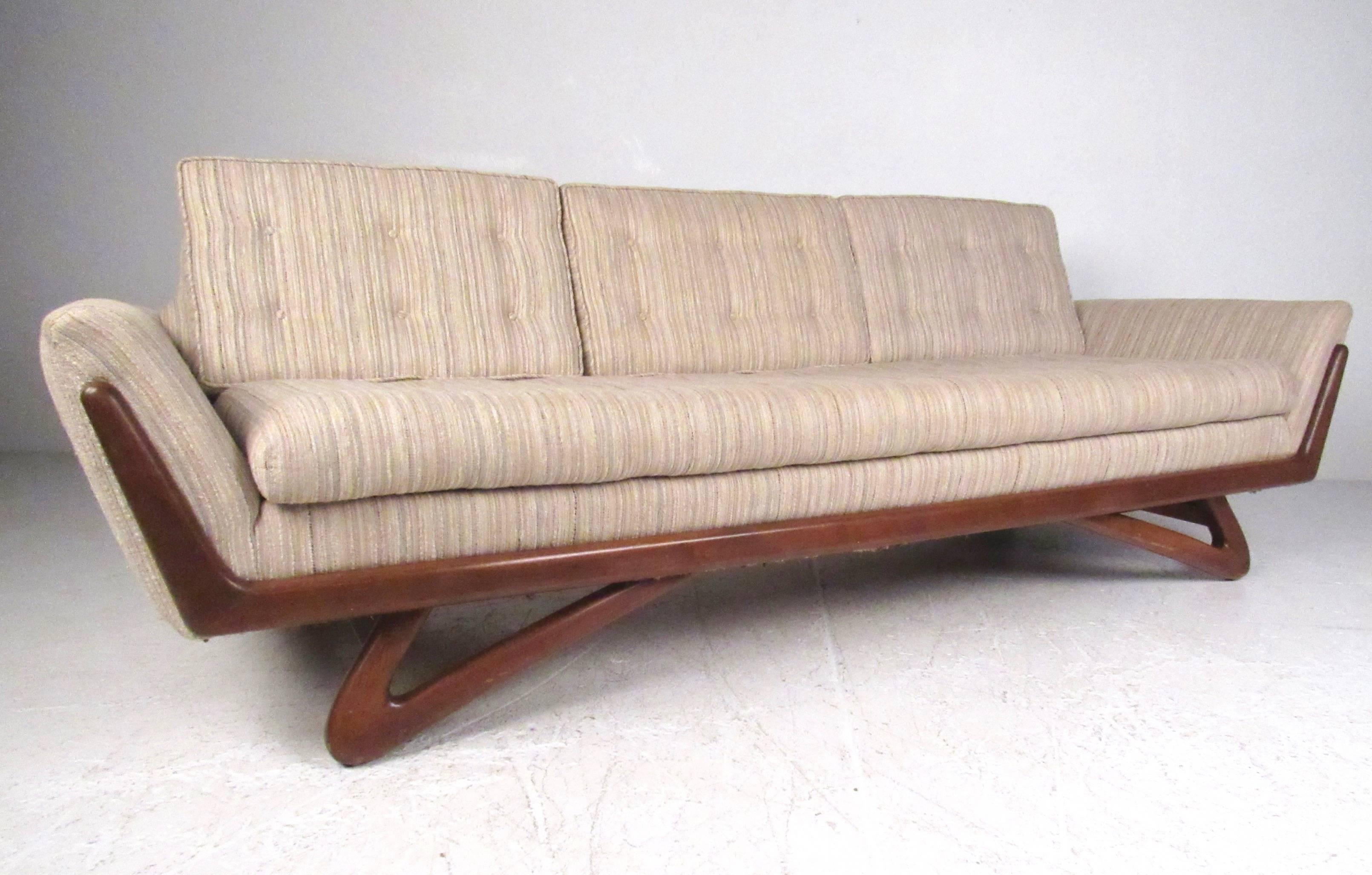 This beautiful vintage modern sofa features the innovative design of Mid-Century great Adrian Pearsall. Sculpted walnut legs and frame paired with tufted vintage fabric and cutaway seat back all add to the appeal of this uniquely shaped 