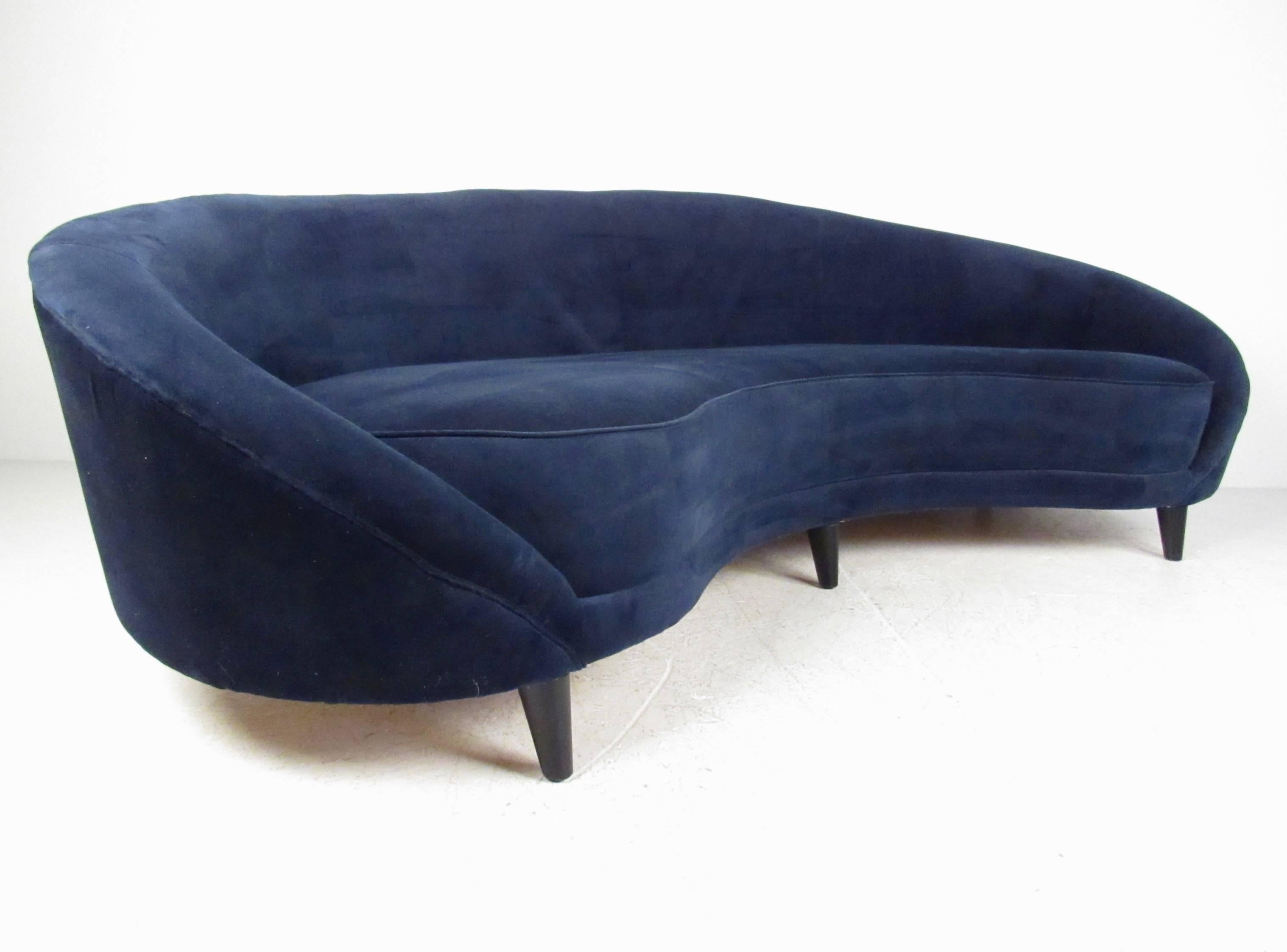 This modern rounded back sofa features comfortable upholstered design with six tapered legs for added support. The impressive size and shape of this beautiful sculpted sofa makes it a unique addition to any seating area. Please confirm item location