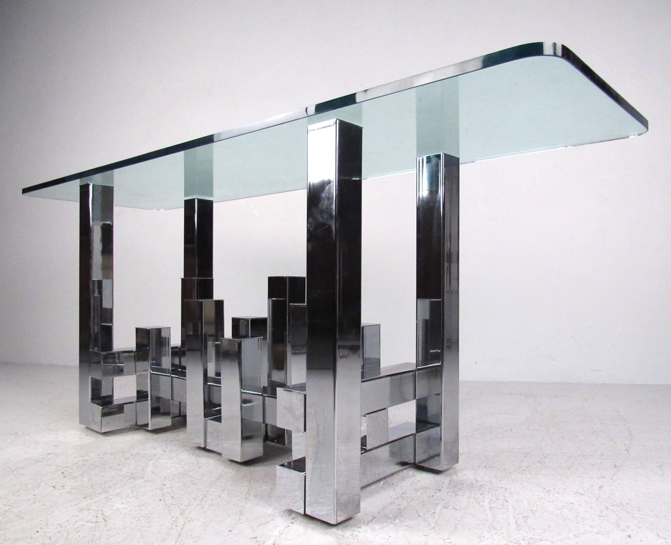 This stunning Paul Evans' style console table features heavy chrome construction in a cityscape type design. Polished metal base supports a thick glass top, making this console table a stylish display piece for any interior. Please confirm item