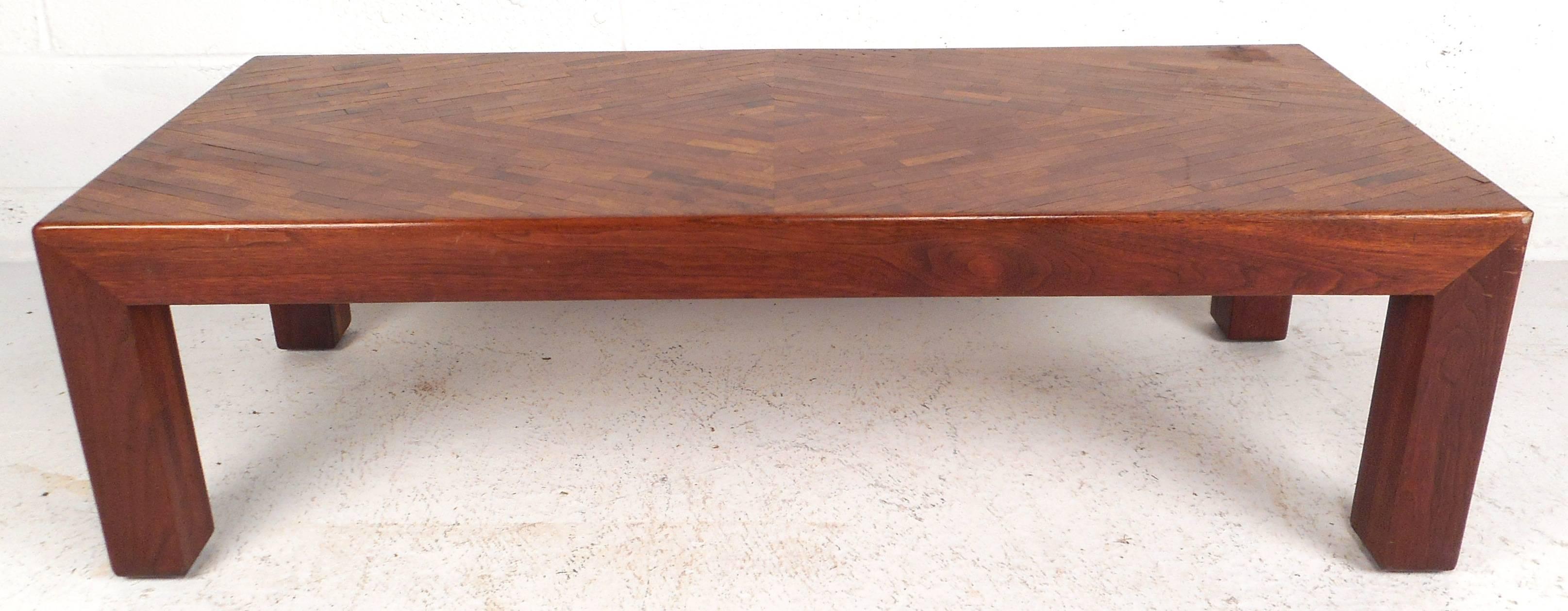 Impressive vintage modern coffee table features a unique patterned in lay design on top. Elegant walnut wood grain, sturdy construction, and clean line work make this Mid-Century piece the perfect addition to any modern interior. Please confirm item