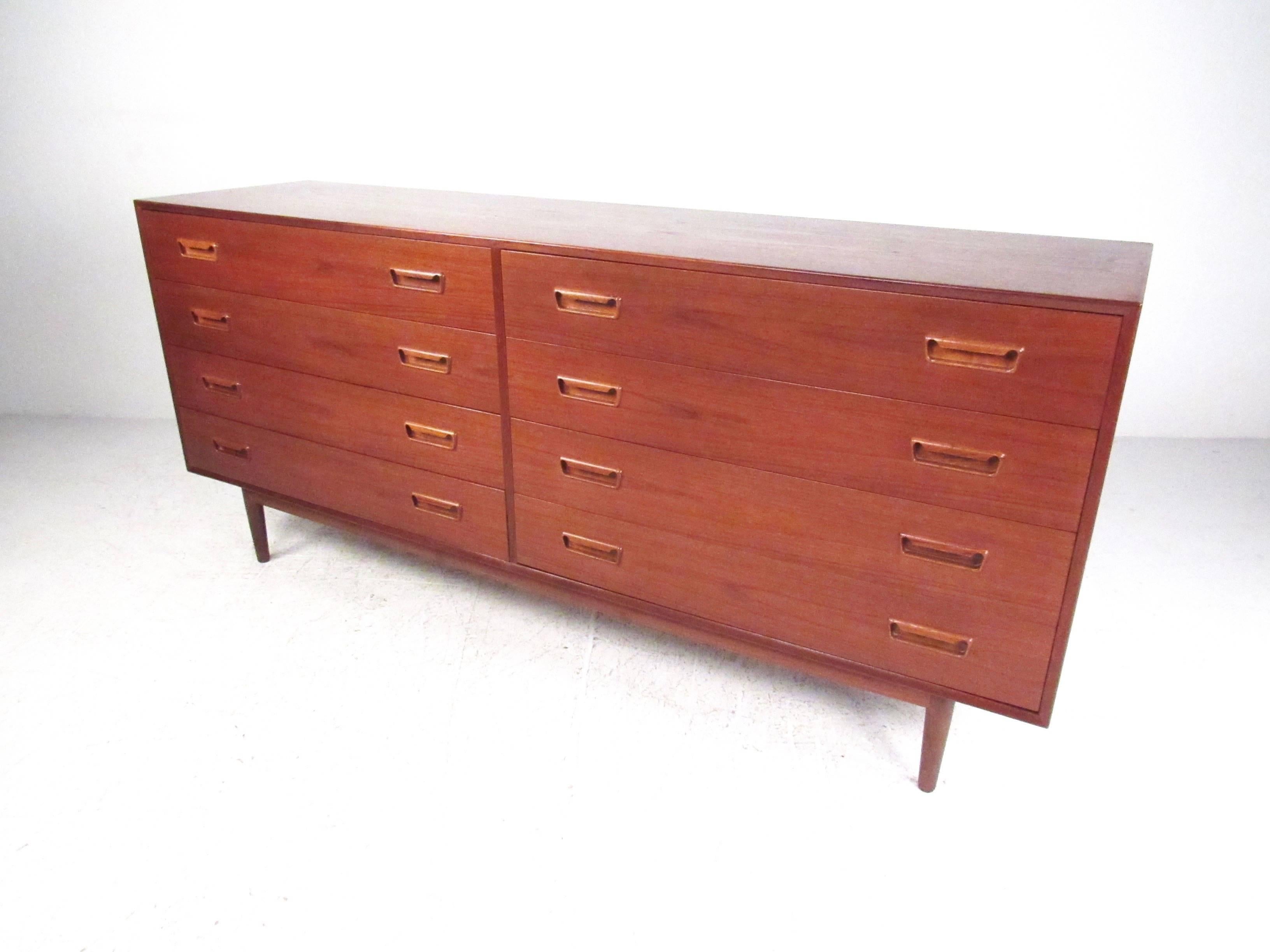 This stunning Mid-Century Modern dresser features spacious eight-drawer construction, a rich vintage finish, and lovely sculpted drawer pulls. Dovetailed joints and tapered legs showcase the quality Scandinavian craftsmanship of the piece. Please