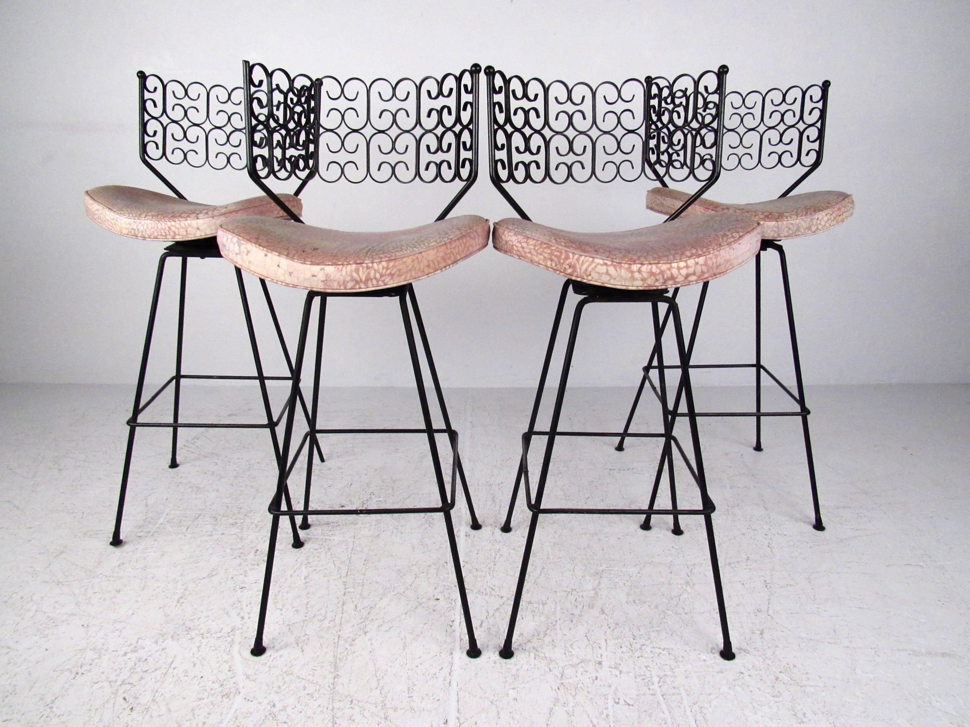 This stylish set of four metal swivel stools feature intricate details and a comfortable design, perfected by Mid-Century master Arthur Umanoff for the Boyeur Scott Furniture company. Part of his Granada line, this matching set makes a unique