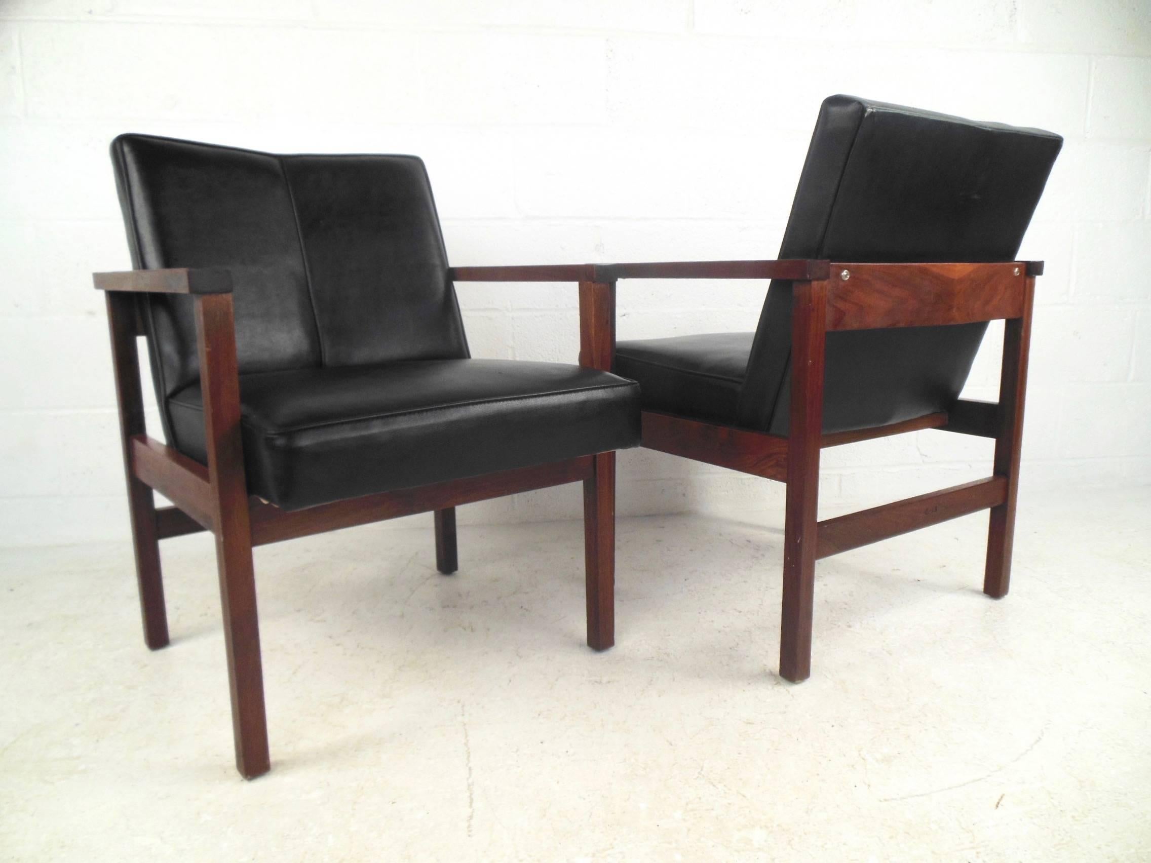 This stunning pair of vintage armchairs feature's sturdy walnut frames with uniquely angled vinyl seat backs. Stylish pair of side chairs by Monarch Furniture Co. make a beautiful Mid-Century Modern addition to any interior setting. Please confirm
