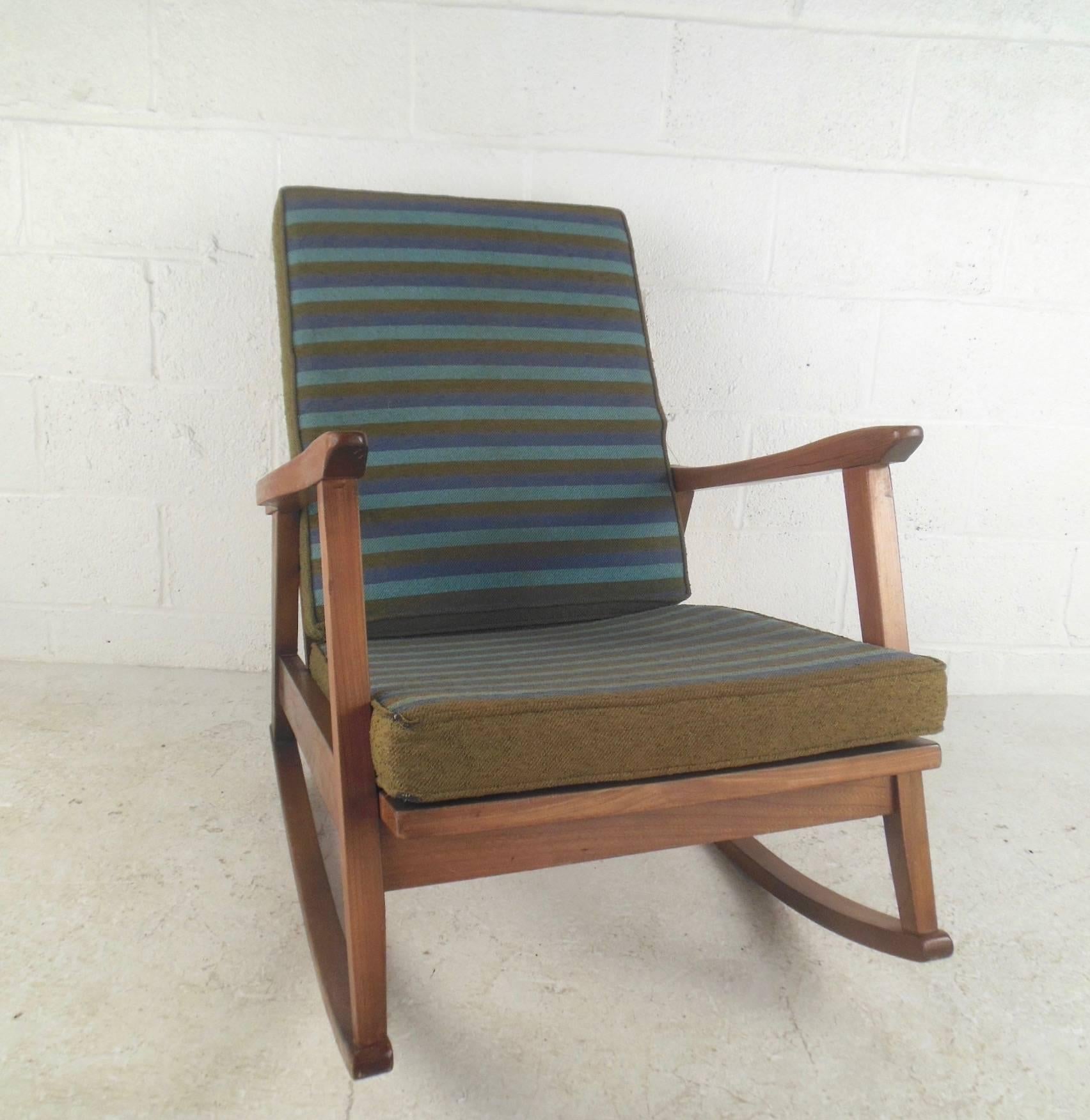 This stunning vintage modern rocking chair features Classic Mid-century design and Pairs American walnut construction with striped vintage fabric. Great rocking chair for any setting, please confirm item location (NY or NJ).