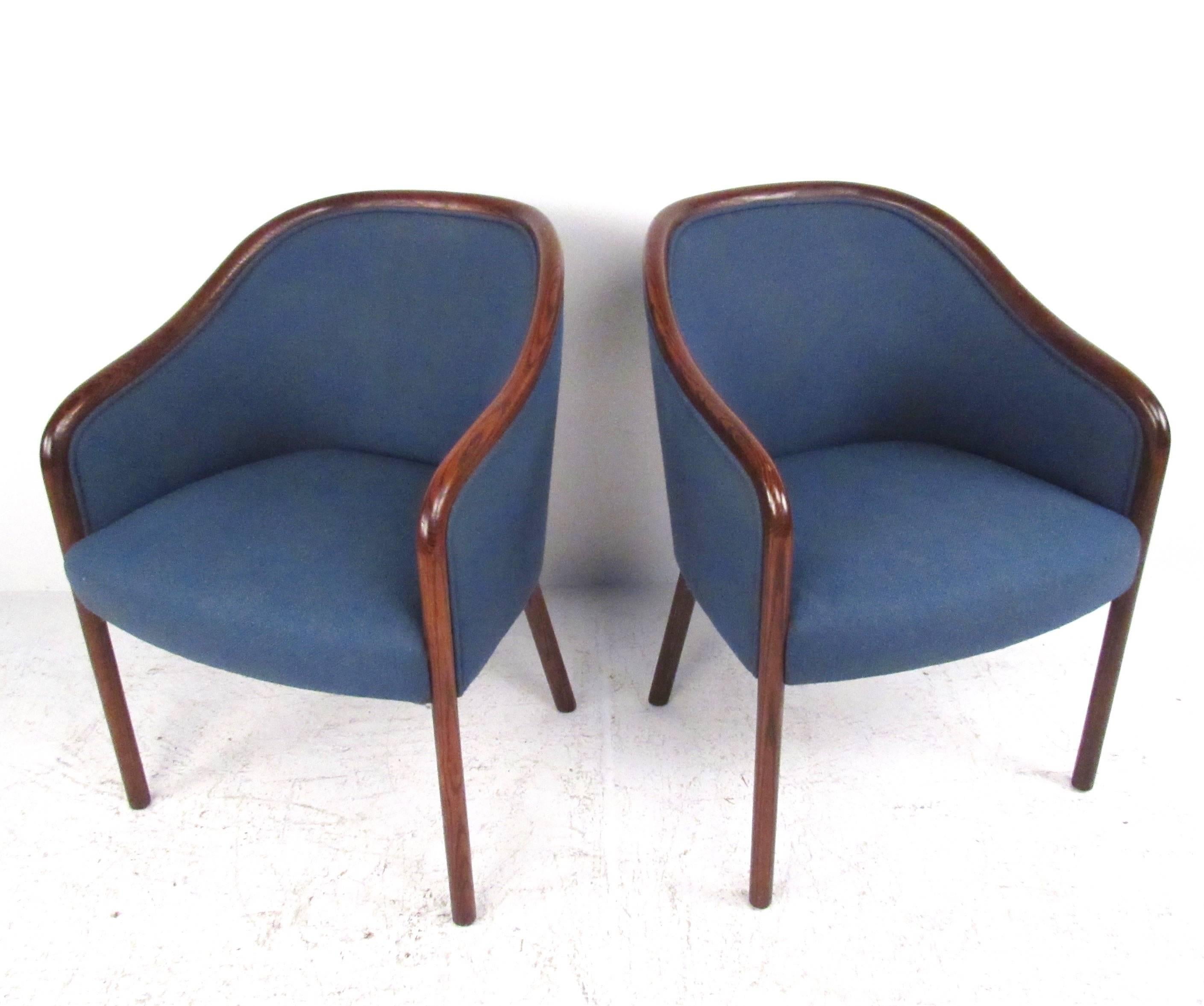 This pair of elegant Mid-Century side chairs features rosewood frames and vintage upholstered seats. Stylish sloped arm design pairs perfectly with rounded seat backs for a timeless mix of comfort and impeccable design. Please confirm item location
