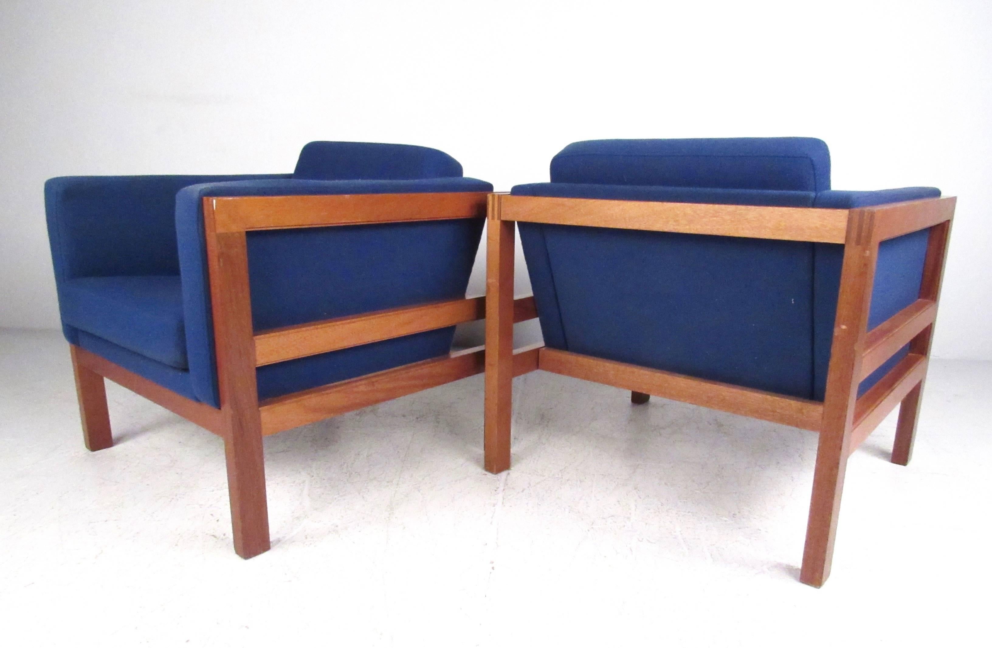 This stylish pair of Danish teak lounge chairs makes a beautiful Mid-Century addition to any interior. Quality dovetail construction, comfortable strap seats, and vibrant vintage blue fabric set this pair apart from other vintage club chairs.