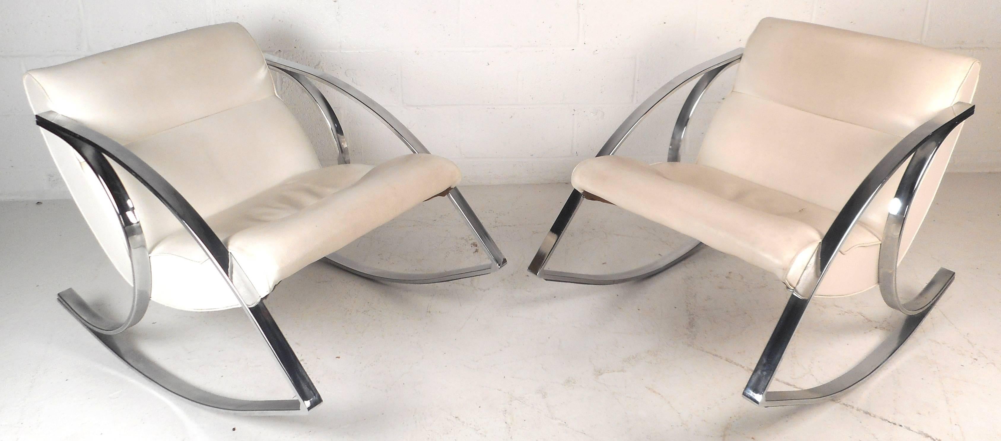 Stunning pair of vintage rocking chairs with a unique sculpted chrome frame. Extremely smooth and comfortable rocking motion with thick padded cushions upholstered in white vinyl. The sleek retro design offers comfort and style in any modern