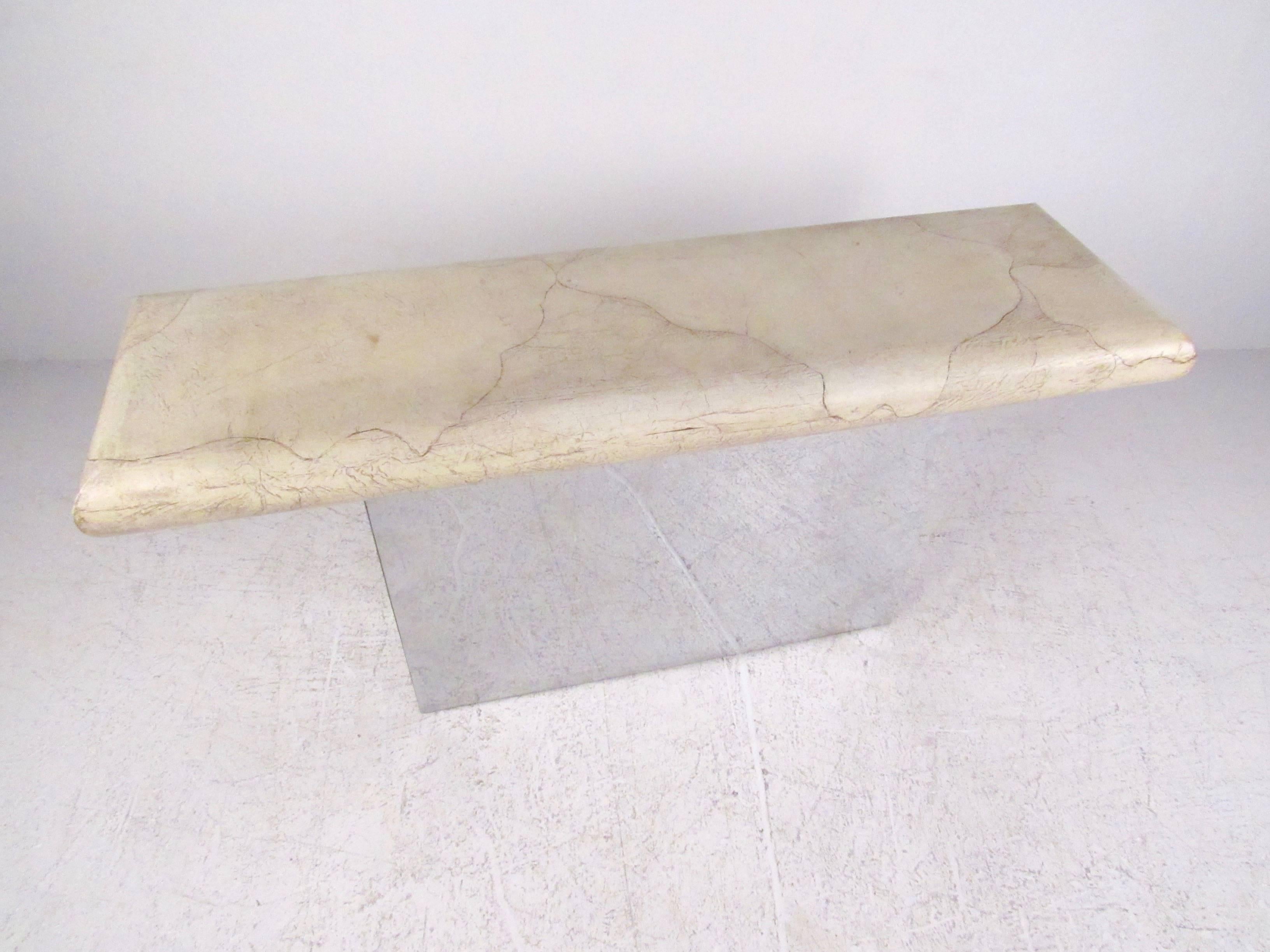 This unique pedestal console table makes a stylish vintage addition to any modern interior. Perfect for use as a console table for entryway display, this Mid-Century table features a polished metal finish on the base and a textured faux marble