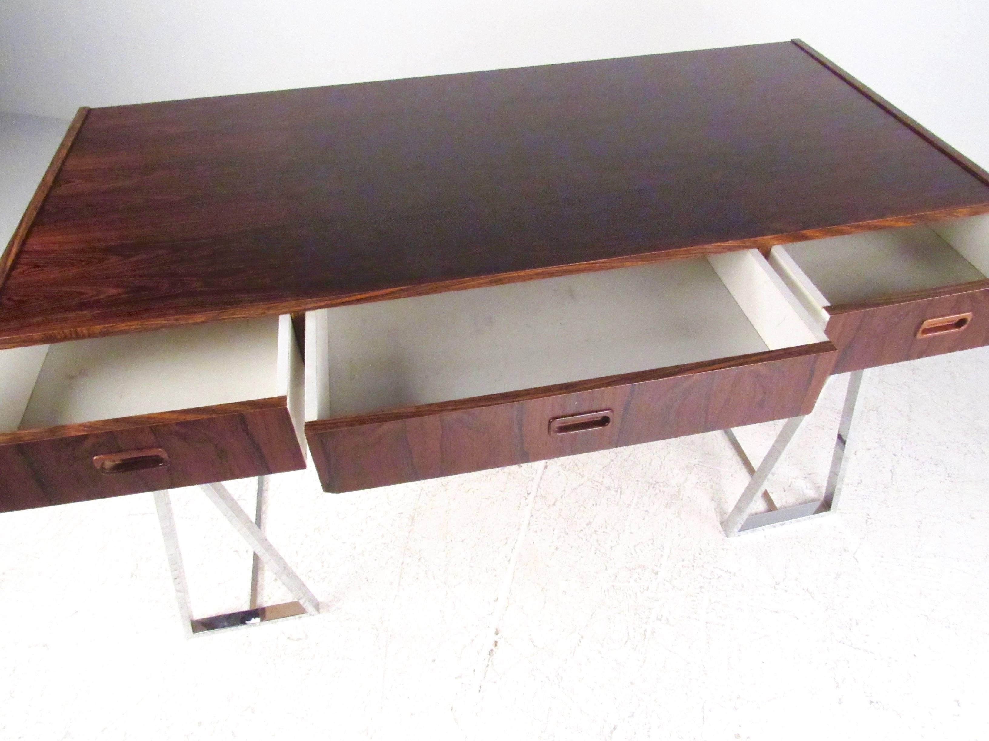 This Mid-Century style Campaign desk features Scandinavian Modern design with chrome finish base and Rosewood veneer desktop. Three drawer design allows for plenty of storage, while the stylish chrome base makes this a unique modern addition to any