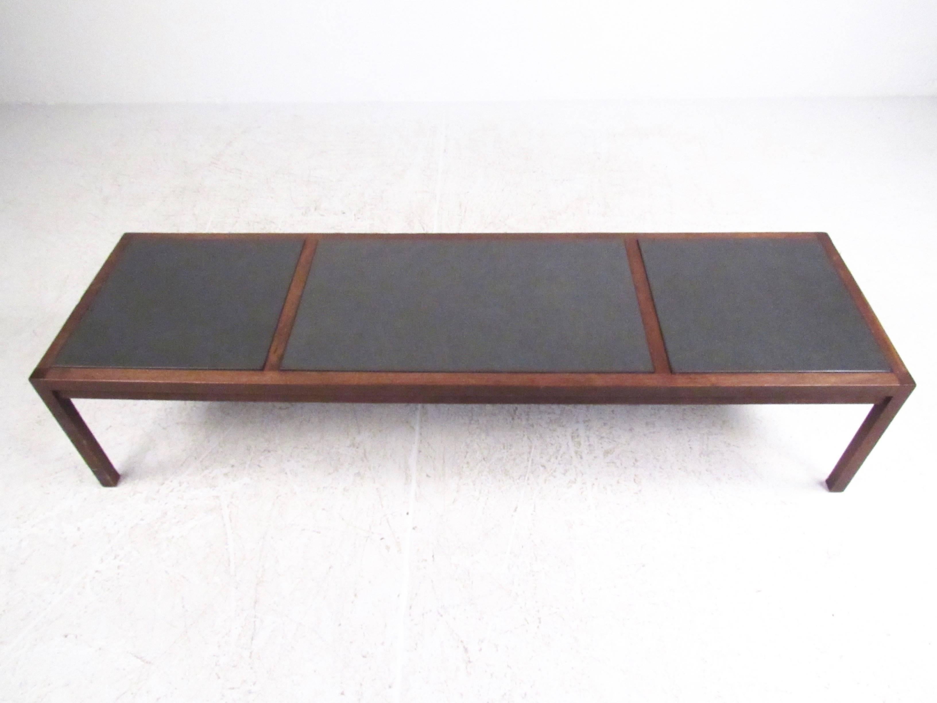 This vintage walnut framed coffee table designed by Jack Cartwright for Founders makes a stylish addition to any seating area, offering a long and low cocktail table that works great with any modern sofa. Unique removable slate inserts add texture