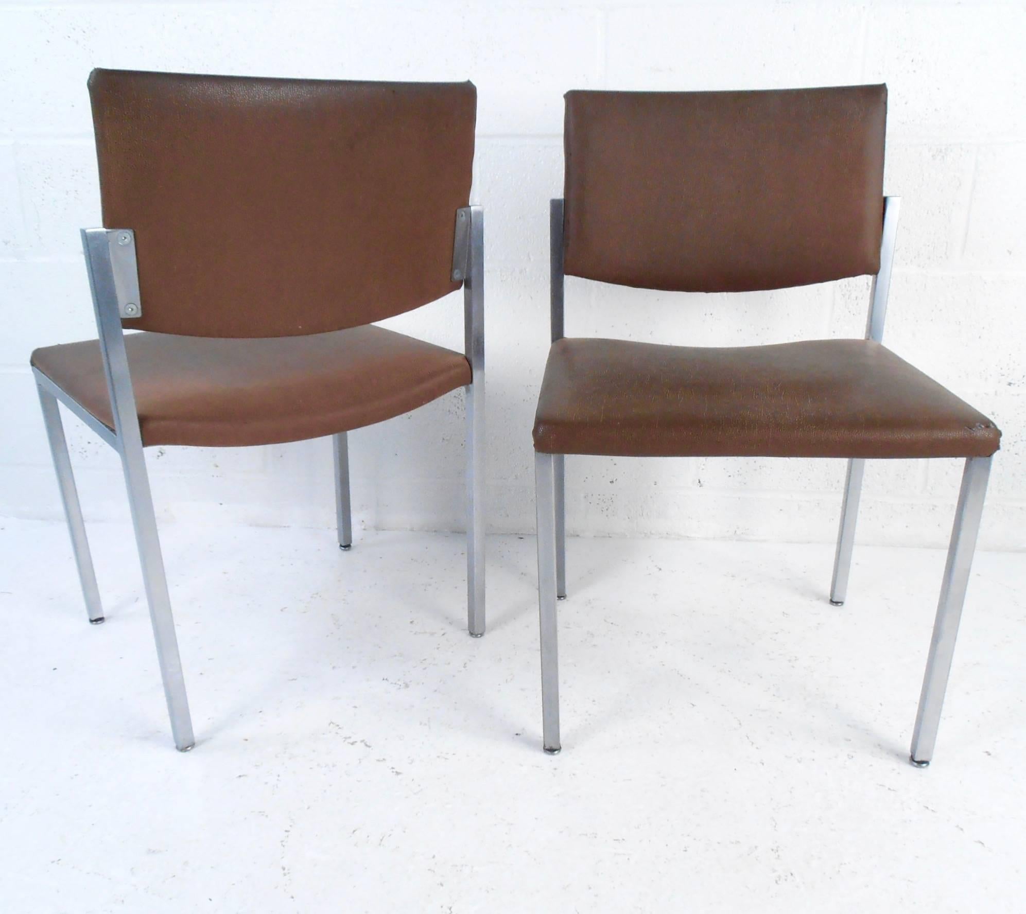 This set of six vintage dining or conference chairs feature upholstered faux-leather upholstery and polished aluminum frames. Comfortable proportions and padding combined with the classic Mid-Century style of the set make these the perfect addition