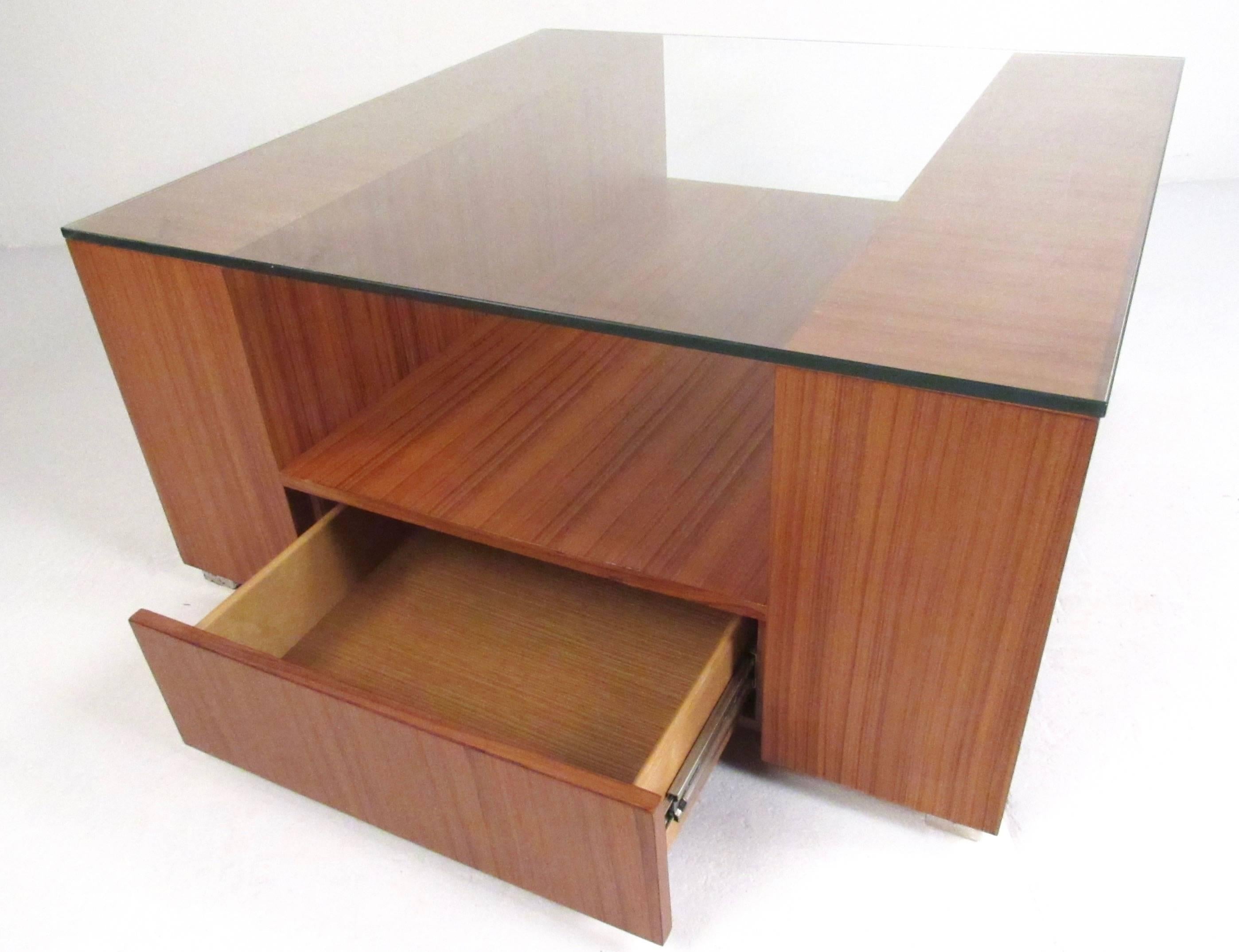 This vintage modern teak coffee table features a stylish two-tier design, a pair of drawers for extra storage and thick glass top. Beautiful Scandinavian Modern table for any modern interior, please confirm item location (NY or NJ).