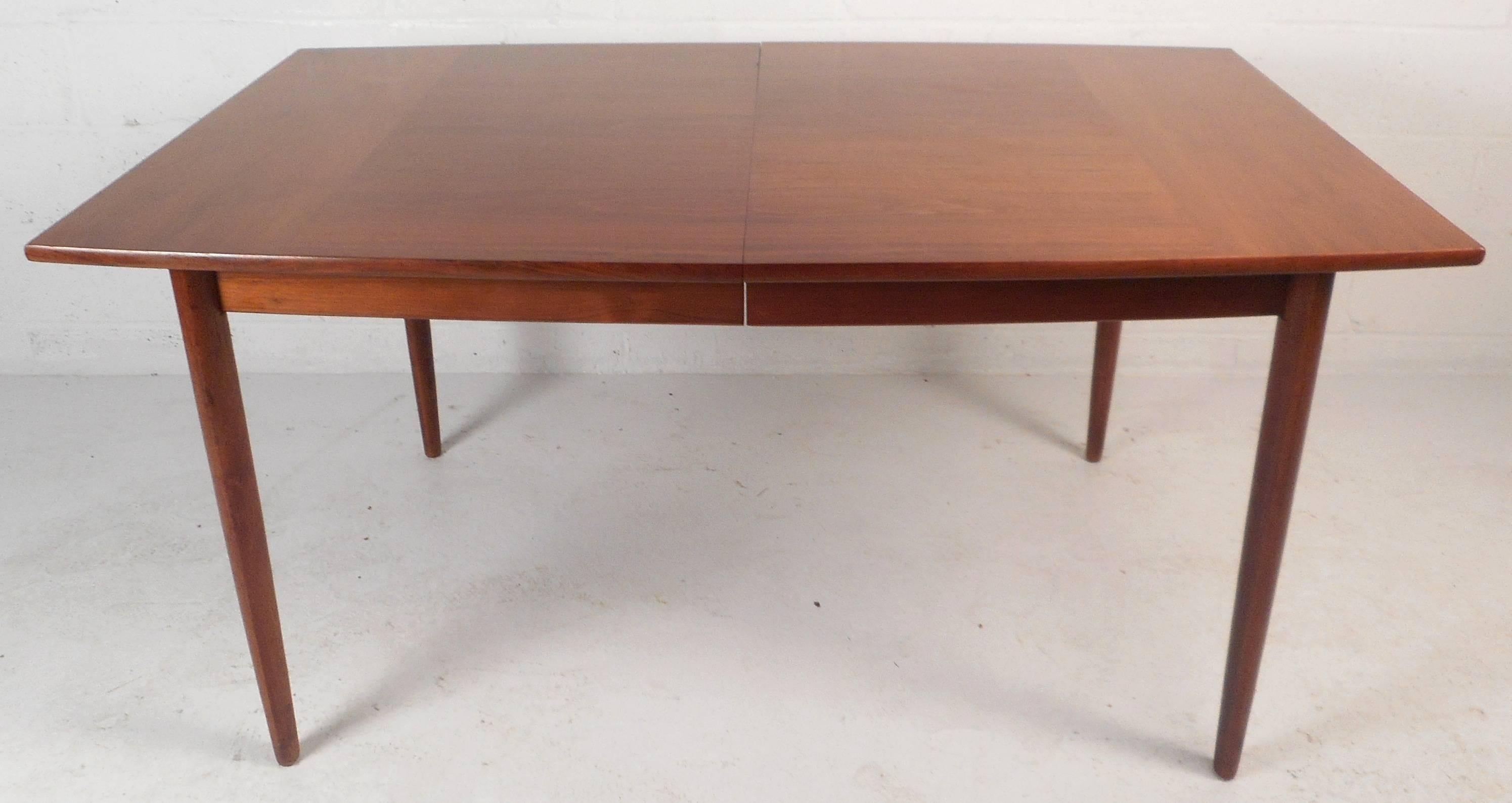 This stunning vintage modern dining table by Drexel features a unique sculpted top with tapered legs. Quality construction with beautiful walnut wood grain. This elegant Mid-Century dining table is sure to compliment any modern interior. Please