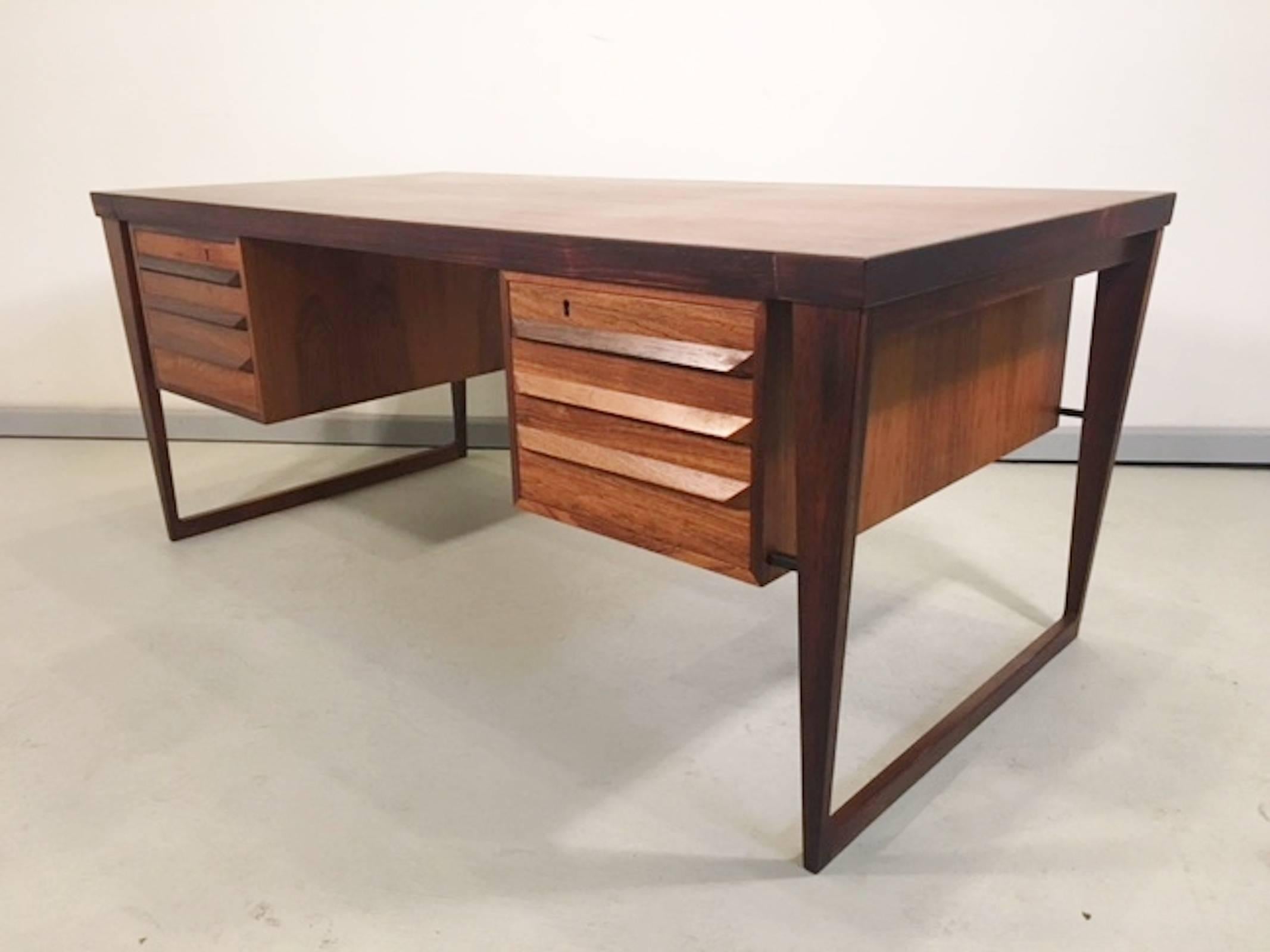 Stunning executive desk designed by Kai Kristiansen, with rich rosewood grain throughout. Six drawers with sculpted handles, wide sled legs and a finished back.

(Please confirm item location with dealer).
               