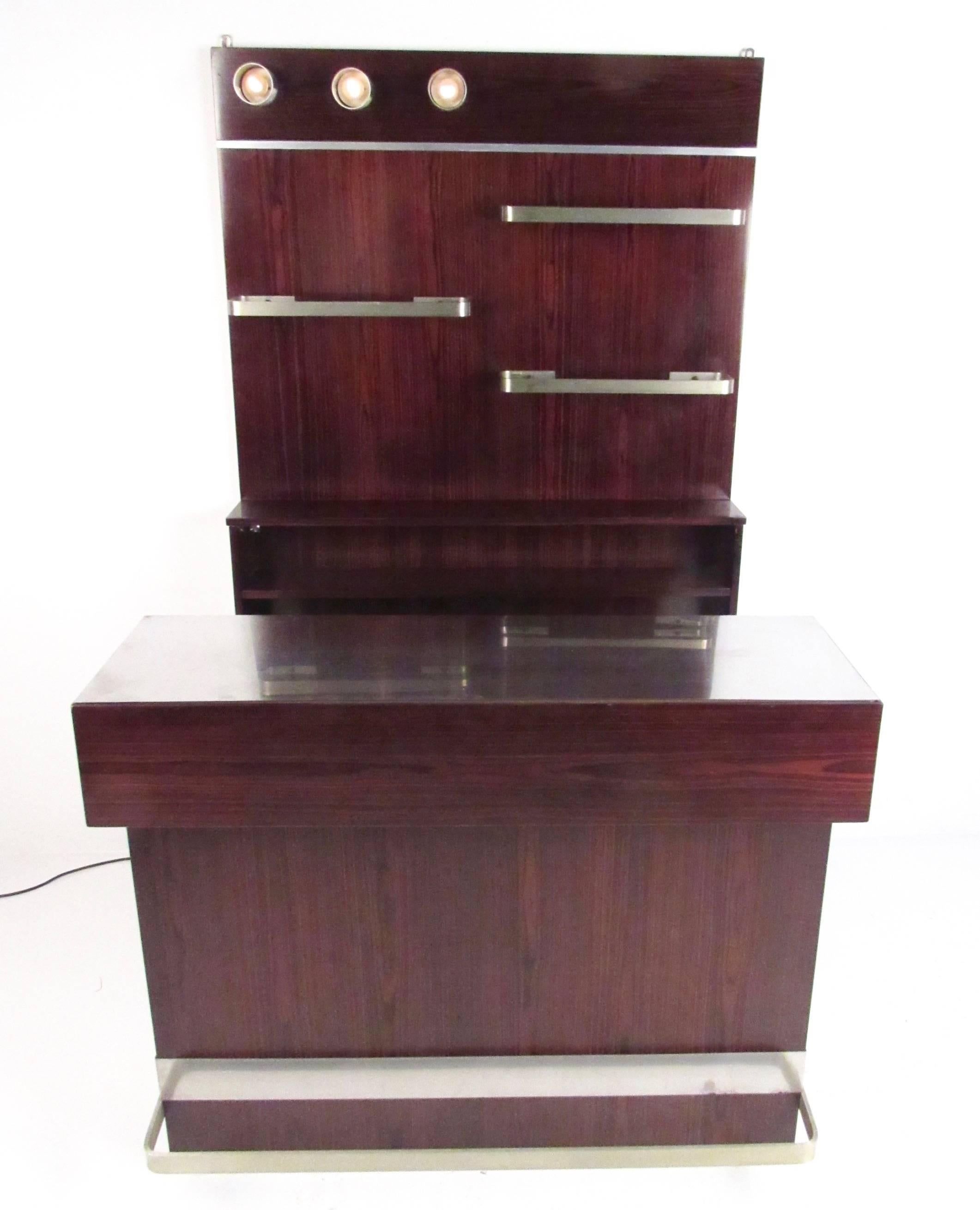 This beautiful Italian rosewood bar set offers a stylish bar cabinet with counter as well as an impressive backlit wall shelf. The stunning wood grain finish of the matching set contrasts well with brushed aluminium trim and foot rail. Please